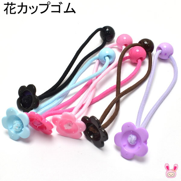 お花型のカップが付いた、カラフルな手芸用のヘアゴムパーツです。花モチーフのカップ部分にリボンやデコパーツを貼り付けることで、可愛いオリジナルヘアゴムを手軽に作ることができます。カップが受け皿のようになるため、大きめのリボンやパーツも安定して接着しやすい仕様です。 接着剤やグルーガンを使ってお気に入りの飾りを付ければ、普段使いしやすいヘアアクセサリーからイベント用の髪飾りまで、作品の雰囲気に合わせて自由にアレンジできます。 赤、ピンク、水色、ラベンダー、黒、茶系など、カラーバリエーションが豊富なので、推しカラーに合わせたヘアゴム作りにもおすすめです。明るい色はキッズ向けの可愛いヘアアクセサリーに使いやすく、落ち着いた色はリボンや布モチーフと合わせてナチュラルな雰囲気にも仕上げられます。 ゴムの先には小さなしずく玉が付いています。ヘアゴムを結ぶ時にこのしずく玉を持ちながら巻き付けることで、最後にモチーフへ引っかけやすくなります。見た目の可愛いアクセントになるだけでなく、ヘアゴムを扱いやすくしたい時にも便利です。 リボンを重ねると華やかに、くるみボタンや布パーツを合わせるとやさしい印象に仕上がります。お花のカップ自体もワンポイントになるため、手芸作品やハンドメイドアクセサリー作りにも取り入れやすいパーツです。 親子やお友達同士で色違いのお揃いヘアゴムを作ったり、プレゼント用のヘアアクセサリーに仕立てたりするのにもぴったりです。販売用のハンドメイド作品にも使いやすい、花カップ付きヘアゴム資材です。 花カップゴム（同色）4個セットのお値段です。 サイズ 全長　約10.5cm カップ　約19mm ゴムの太さ　約2.2mmです。 ※入荷時期により色味やサイズにバラつきがある場合がございます。　 ※入荷時期によって加工過程で出来た色ムラや塗料の付着などがある場合がございます。 ※入荷時期により価格の変動がございます。予めご了承ください。 小さいしずく玉パーツ 10個セット（商品番号10020098）もご用意しています。ぜひあわせてご覧ください。