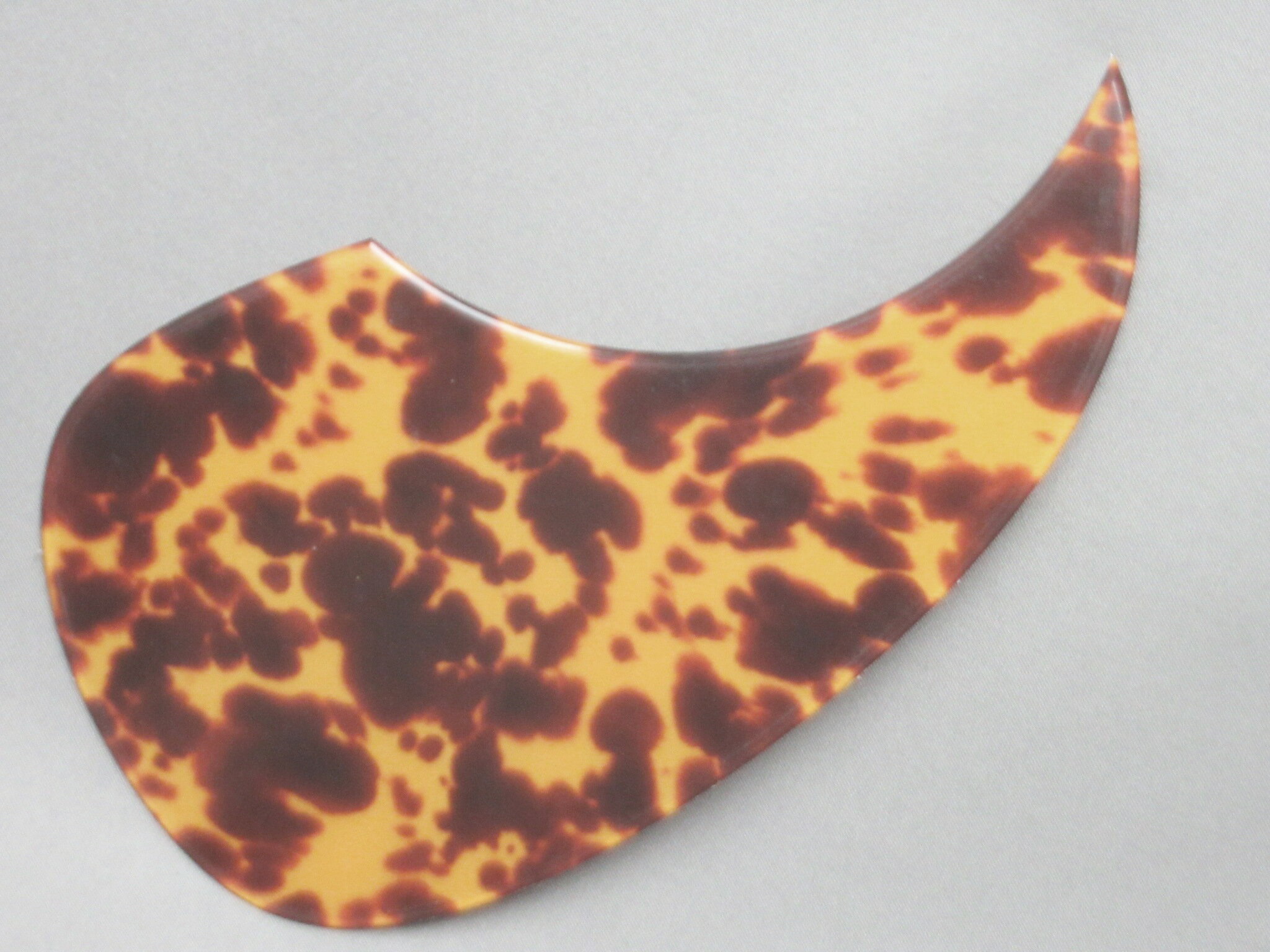 画像をご覧のように商品の外周は丸くR加工され、高級ギターに装着されているピックガードのような高い質感です。 この品の厚みは1mmありますので一般的な0.5mm厚のものと比べると倍近い厚みがあるので存在感も違います。 また、当店にはさらに厚い「厚手タイプ」も販売していますが、そちらの厚みは2mmあり、お客様によっては「さすがに2mmは厚すぎ」とか「ギターの鳴りが抑えられそう」と思われる方もいらっしゃると思います。 でも高級感は欲しいという方はこの1mm厚のタイプがもっともバランスの取れた商品だと思います。 装着は、裏に粘着シートが貼ってあり、台紙を剥がしてギターに貼るだけですので簡単です。 サイズは横・約95mm、高さは約172mmです。(あくまでも水平、垂直のそれぞれの一番長さの取れるところで測っています) ピックガードの内径は直径5インチ(12.7cm)用 このピックガードは、いわゆるマーチンD-28(18・35など)タイプのシェイプです。( D-28タイプですのでD-28と全く同形状というわけではありません。誤解のないように) この商品の普通郵便の送料は下記の料金表を。　合わせて注意点をご覧ください。普通郵便発送希望の方は注文時の画面の発送方法を普通郵便に変更しないと普通郵便に変更されませんのでご注意ください。