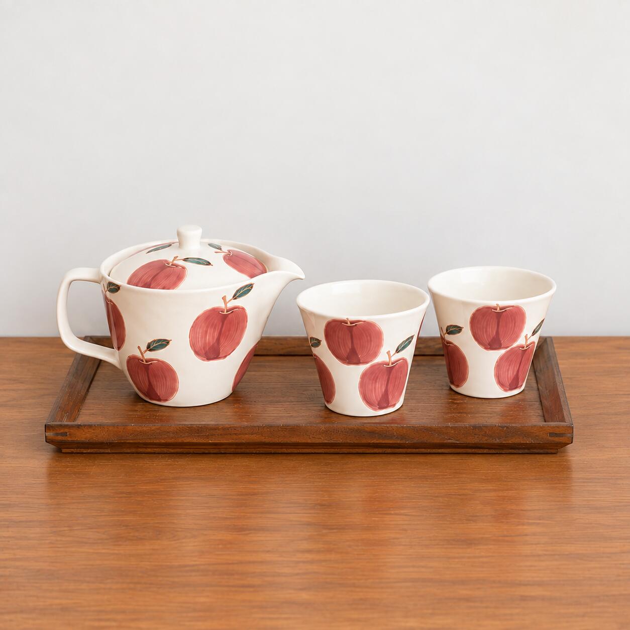 日本製 波佐見焼 菊祥陶器 フレッシュアート　 林檎 茶器セット 日本製 波佐見焼 磁器 ポット 仙茶 茶器セット 木箱 マット おしゃれ かわいい ティータイム ギフト 内祝い プレゼント 引き出物 お正月 結婚祝い 誕生日 贈り物 自宅 飲食店 うつわ 器 〇サイズ　【ポット】　縦 10cm ・ 横 14.3cm (注ぎ口から取手まで)　高さ 10m (蓋のポッチまで)・ 容量 約 250cc　【湯呑】　　口径 7.8cm ・ 高さ 7cm ・ 底径 4.5cm　　容量 約 130cc〇産地　長崎県 波佐見市レンジ：〇食洗機：〇つや消しのアイボリーに赤いリンゴが目を引くポット 1個と湯呑 2個のセット。ポットは小振りで扱いやすく、湯呑も小さめですので女性やお子様の手にもちょうどいい大きさです。ポットには茶こしアミが付いておりますので、使用後の茶葉の片付けが簡単です。くつろぎのティータイムが ちょっと華やかになりそうなポットと湯呑のセットです。贈り物にも いかがですか！※画像にあります 林檎絵の茶器 以外の商品は別売りです。■商品の撮影には最大限の注意を払っておりますが、閲覧時のモニター環境によりましては実際の商品と若干違うお色味に映ることもございます。■それぞれが職人さんによる手描きのうつわですので、商品によっては絵付けの雰囲気や柄の様子などがイメージと異なる場合がございます。 味わい、表情として受け取っていただくと幸いです。■こちらの商品は他のルートでも販売しております関係上、ご購入のタイミングによっては品切れが発生する場合もございます。大変恐れ入りますが、その場合はメールにてご連絡させて頂きます。 5