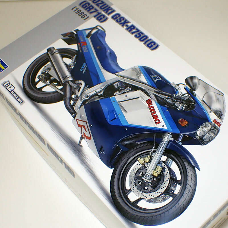 1/12 スズキ GSX-R750(G)(GR71G)【ハセガワ BK7】 大排気量レーサーレプリカの礎を築いたスーパーマシン 1985年に登場したスズキGSX-R750は、油冷エンジンを装備して当時の400ccクラスに匹敵する軽量化を実現し、ナナハンバイクは重くて乗りづらいという概念を根本から変えました。油冷エンジンとは、エンジンオイルを冷却媒体として活用する液冷エンジンのことで、冷却水ラジエーターを装備する水冷エンジンより軽量にすることが出来ました。キットは1986年に発売された「GSX-R750（G）（GR71G）」（2型）を、徹底した実車取材により完全新金型でキット化します。 ※組立＆塗装が必要なプラモデルです。