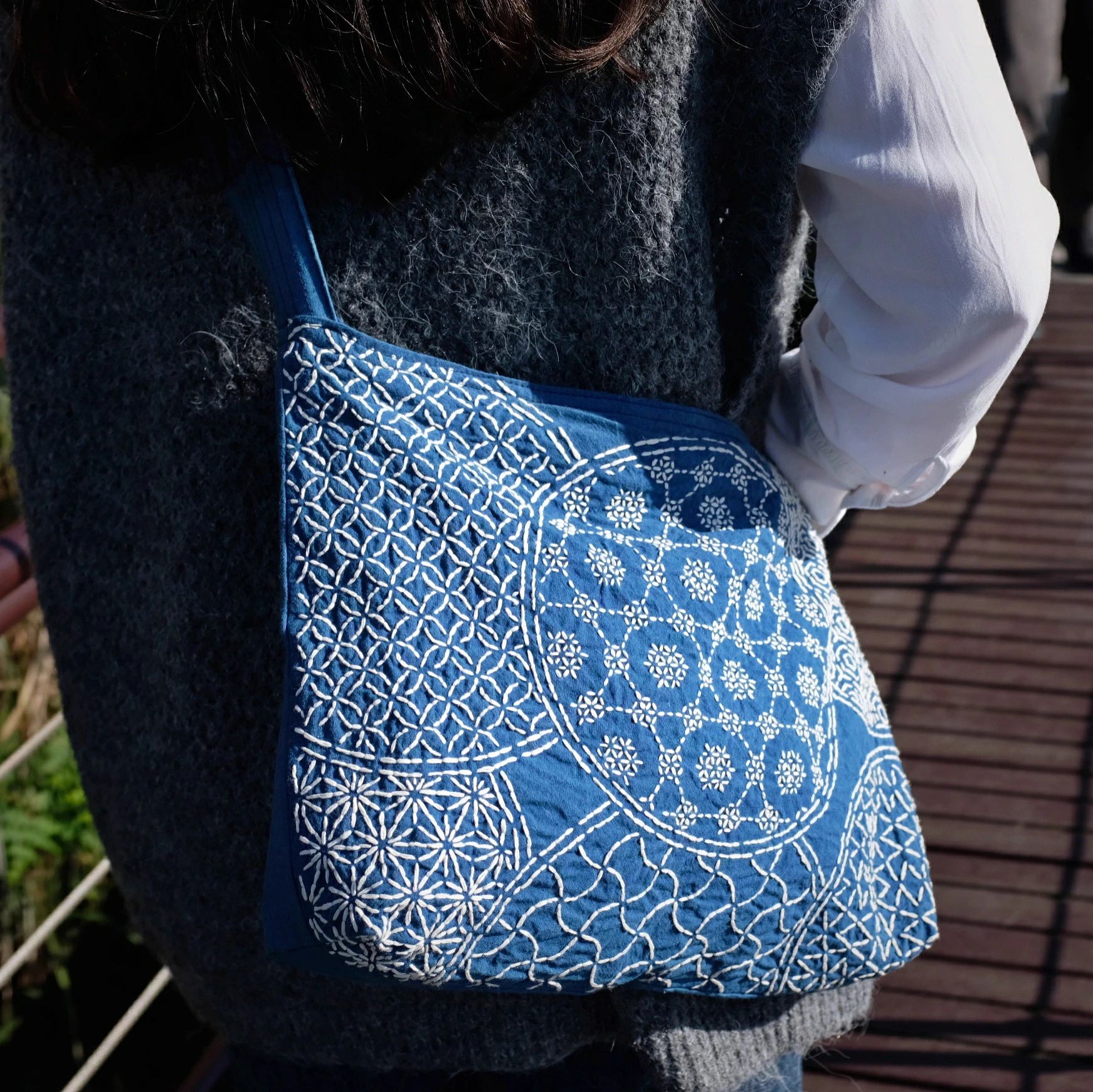 藍染 刺し子 刺繍 ショルダーバッグ 重工 団花模様 大容量 斜めがけバッグ ハンドメイド オリジナルデザイン YKKファスナー付き 手仕事 ハンドメイドバッグ 大容量 / ナチュラル / プラントダイ / サステナブル 刺し子 藍染大容量 斜めがけバッグ 花団錦簇、藍に咲く白の物語一針一針、丁寧に縫い込まれた刺し子の模様。初めて目にしたとき、まるで唐代の錦織文様のような壮麗さを感じました。花が集まり、咲き誇る姿はまさに盛世の風景。深い藍に映える白い糸は、清らかで凛とした佇まいを漂わせます。天然素材 × 手仕事のぬくもり・伝統的な藍染め × 白糸刺繍・ひとつひとつ異なる風合い・植物染料ならではの柔らかい色合い量産品にはない、唯一無二の存在感。日々使うほどに、手仕事の温もりが馴染んでいきます。機能性と心地よさバッグ幅：38cm高さ：28cm底マチ：約7.5cm肩ひも：幅4.5cm × 長さ90cm（加幅デザインで肩にやさしい）内ポケット：4口付き（小物の整理に便利）YKKファスナー使用で安心肩ひもは複数の縫製でしっかり補強。型崩れしにくく、荷物を入れても安定感があります。日常に溶け込むアートのような存在本やノート、日常の小物はもちろん、大容量でお出かけや旅行にもぴったり。シンプルな服装に合わせても、この藍と白のコントラストが装いのアクセントに。物語を持つバッグこのバッグはただの収納ではありません。千年続く刺し子の伝統、植物染めの藍の深み、そして一針に込められた作り手の想い。持つ人それぞれの日常に寄り添いながら、小さな物語を紡いでくれるでしょう。👉 あなたのお出かけを少し特別にする、世界にひとつだけの 藍染刺し子バッグ をぜひどうぞ。 5