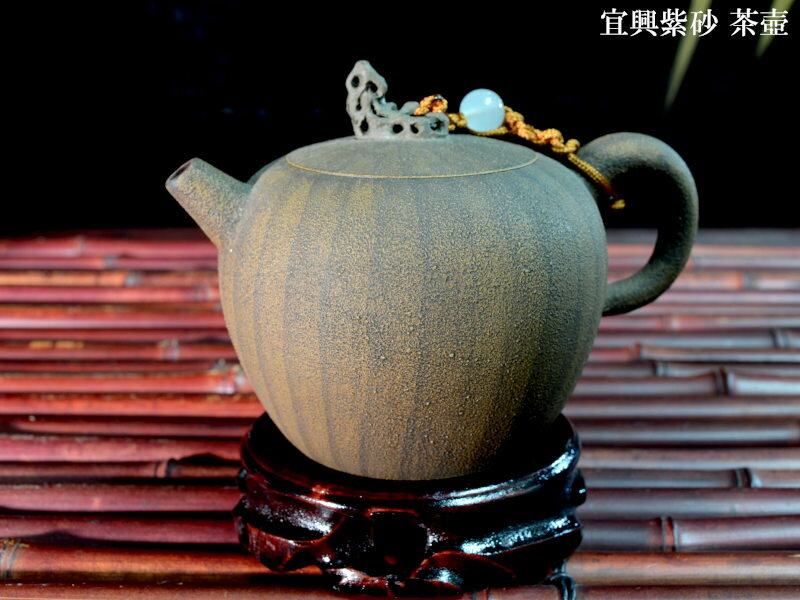 中国江蘇省宜興は陶器で有名な都市です。独特な味わいを持つ紫砂（しさ）という有名な茶器の産地です。この紫砂の茶壷でお茶を入れると、お茶の渋みなどが茶壷に吸収され、美味しくいただけると言われています。また紫砂の茶壷はコレクターが多いことでも有名です。実際には使用しないで茶架などに飾り眺めて楽しむのも。本商品はざらっとした手触りの瓜子型の茶壷です。一点のみです。箱入りなので贈り物にも 【新しい茶壷を使う前に】紫砂の茶壷を使う前には一手間かけなければいけません。壷の内部に砂や泥が残っているのでこれを落としてから使いましょう。古くなって柔らかくなった歯ブラシで、茶壷をこすります。水、ぬるま湯、お湯と3回に分けて注ぎこぼしをして、内部の土砂を吐き出させ、最後にもう一度歯ブラシでこすってあげましょう。 【商品詳細】 ・サイズ　約　幅12.5cm×胴部直径φ9cm×高さ8cm ・重量　約184g ・容量　約250cc ・中国宜興製 ・一点のみ ・壺縄付き、箱入り ※画像の花台は付属しません（別売り） ★実物は下記店舗にてご覧いただけます （株）中国貿易公司中華街一号店2.0宜興紫砂茶壷　瓜子壺瓜子型の宜興紫砂茶壷です 中国江蘇省宜興は陶器で有名な都市です。独特な味わいを持つ紫砂（しさ）という有名な茶器の産地です。この紫砂の茶壷でお茶を入れると、お茶の渋みなどが茶壷に吸収され、美味しくいただけると言われています。また紫砂の茶壷はコレクターが多いことでも有名です。実際には使用しないで茶架などに飾り眺めて楽しむのも。本商品はざらっとした手触りの瓜子型の茶壷です。一点のみです。箱入りなので贈り物にも