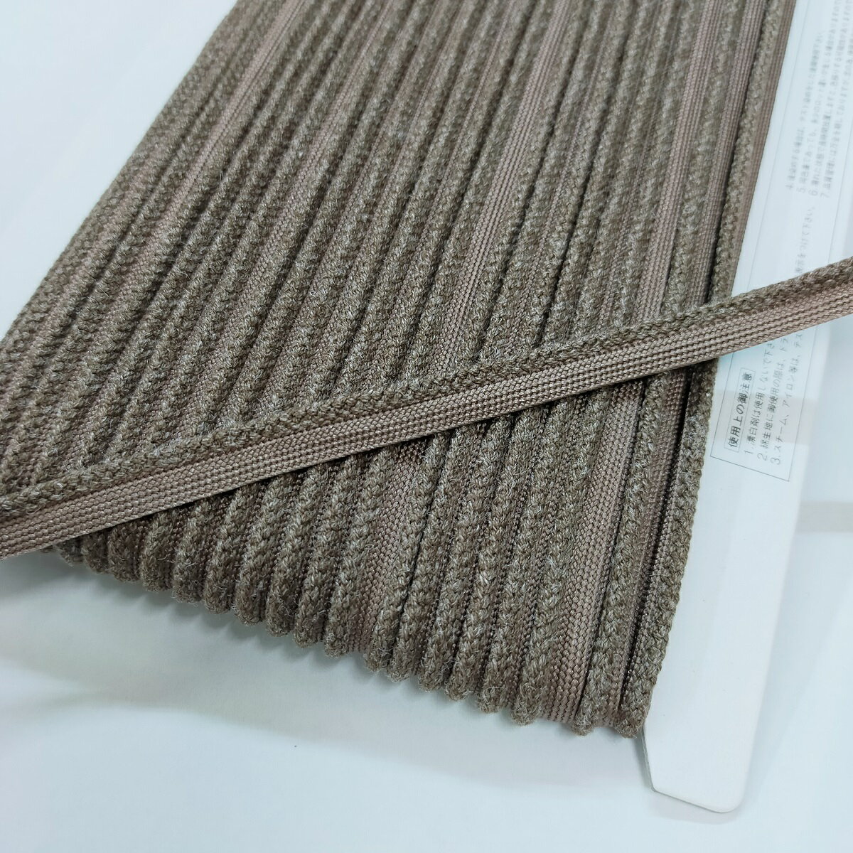 商品詳細 素材 ひも:アクリル/麻　テープ:ナイロン 長さ 30m 巾 紐部分：約2.5から3mm　テープ部分：約5から6mm 生産国 日本 特徴 クッションやバッグの縁取りにお使い頂けます。 ご注意 濡れた状態で放置されますと、 色移りする場合がございます。 1ケ所は、つなぎが有る場合がございます。 定番商品から外れた為、安価にしています。" width="500">
