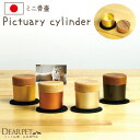 ピクチュアリ シリンダ Pictuary cylinder ミニ骨壷・フォトフレーム 写真を飾りながら供養できる ミニ骨壷です 私たちの暮らしにそっと溶け込み、ペットちゃんと身近に寄り添うことができる、 そんな「さりげない供養」をさせてくれるのがこのミニ骨壷です。 和室にも洋室にも合う仏具を、とデザインしたところ、 優しさを感じる形と、控えめな佇まい、しっかりとした素材感を表現することができました。 ご家族の集まるリビングに置いても、静かな寝室のわずかなスペースに置いても、 違和感なくペットちゃんを想う大切な場所にしてくれます。 「骨壷」としてご案内しておりますが、 毛や歯、爪、ひげなど、ペットちゃんの小さな遺品を納めてご供養ください。 - アイテム名 - 写真が飾れるミニ骨壷「ピクチュアリ シリンダー」 商品番号（お問い合わせコード）：f00ha04 - サイズ・材質 - 直径 約4.6cm×高さ 約5cm 付属品：敷マット 材質：真鍮、木材 - 納期 - こちらはお取り寄せ品です。 ご注文の日から約2週間でお手元に届けいたします。 - 備考 - ■国産（富山県製） 真鍮は空気中の成分と反応してくすんだり黒ずんだりする性質があります。 手作業の温かみ、素材の持つ味わいとしてご了承いただきますようお願い申し上げます。 （ディアペットでは職人さんの目で良品と確認をしていただいたお品物のみを発送しております）