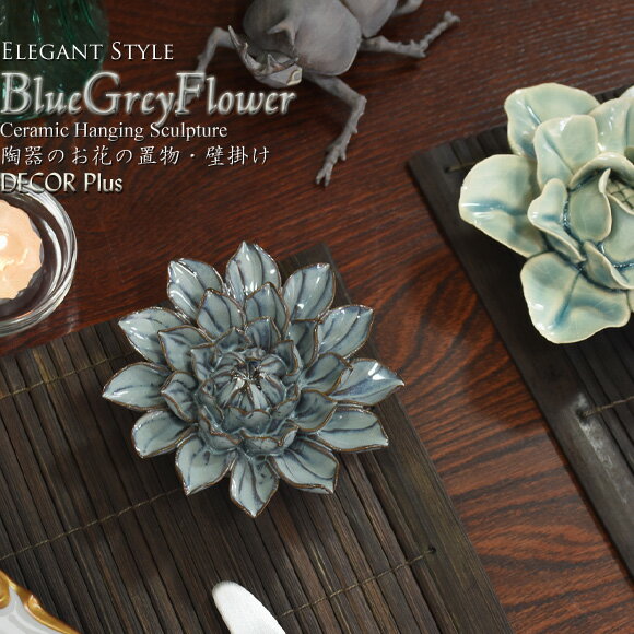 商品名：ブルーグレイフラワー　陶器のお花の置物 壁飾り シックな色合いが印象的なお花の形をした置物。 陶器で作られたお品で、背面にはフック穴が開いており、壁掛にもなるお品です。 幾重にも細かく重なり合った花びらは一つ一つ曲線がつけられ、リアルな風合い。 直径約10cmと小ぶりなサイズですが、全体的にふくらみのあるフォルムがエレガントでかわいらしさを感じさせます。 約200gと軽い重量ですが、陶器で作られているためか、しっかりした重さに感じられますよ。 先端部分に鋭い箇所やカケやムラなど若干ですが作りに難があるお品も含まれますが、小粒ながらしっかりとした作りの存在感は捨てがたい！ 数量限定ですので、お早めに！ サイズ：H約4×W約10×D約10(cm) 背面　：直径約4.5(cm) 重さ　：約200g 素材　：陶器 中国製 　【数量限定】エレガントスタイル ブルーグレイフラワー　陶器のお花の置物 壁飾り ＜Good Point！　バイヤーズ　CHOICE Point＞ 「陶器で作られたエレガントな存在感」 シックな色合いが印象的なお花の形をした置物。 陶器で作られたお品で、背面にはフック穴が開いており、壁掛にもなるお品です。 幾重にも細かく重なり合った花びらは一つ一つ曲線がつけられ、リアルな風合い。 直径約10cmと小ぶりなサイズですが、全体的にふくらみのあるフォルムがエレガントでかわいらしさを感じさせます。 約200gと軽い重量ですが、陶器で作られているためか、しっかりした重さに感じられますよ。 先端部分に鋭い箇所やカケやムラなど若干ですが作りに難があるお品も含まれますが、小粒ながらしっかりとした作りの存在感は捨てがたい！ 数量限定ですので、お早めに！ サイズ：H約4×W約10×D約10(cm) 背面　：直径約4.5(cm) 重さ　：約200g 素材　：陶器 ※薄い色のお花は別売りです。 【海外ハンドメイド、アンティーク加工品について】 こちらのお品は海外職人によるハンドメイド品のため、作りにムラがあるお品も含まれております。 細かなカケやキズ、くすみやムラ、凹み、色のはみ出し等があるお品が含まれております。 また、現地職人によるハンドメイド製のため、色ムラ、若干のカケ、ヒビ、キズ、汚れ、べとつきなどの様々なムラがある場合がございます。 また若干グラついたり、傾いているお品が含まれる場合がございます。 当店にて検品の際に不備が目立つお品は除いておりますが、海外ハンドメイドの特徴として予めご了承下さい。 また、大きさや色の仕上がり等、商品ごとに個体差があります。 入荷時期によっては加工の色合い、風合いが写真と異なる場合がございます。 ※品質よりデザインを重視して仕入れましたので、デザインの美しさを求める方向きの商品です。 （デザインが予告なく変更する場合がございます） ※実際見た場合と同じ色合いになるよう、商品撮影には最善の努力をしておりますが、ご覧頂いてる環境やパソコンによって、若干色が異なって見えることがございます。 何卒ご了承ください。 【★お届けは宅配便でのお届けです（メール便不可）★】
