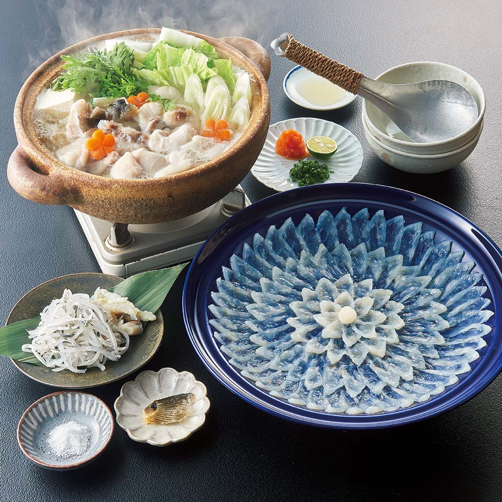 美味しい国産とらふぐの刺身と鍋を心ゆくまで味わえます。通常お届け：毎週火曜日までのお申込分を翌週土・日曜日にお届けします。年末お届けお申込締切日：12月16日（封書は12月16日必着）年末お届け：12月28日〜29日の日時指定を承ります。ふぐ専門業者「ふく太郎本部」では、一年中、美味しいふぐを提供。アジやサバ、オキアミなどを与えながら自然に近い状態で育て、本物の味にこだわっています。透けるほど薄く開いた刺身はぷりぷりの食感。濃厚なだしが楽しめるふぐ鍋も堪能できます。【冷凍方法】刺身を引き立ての美味しさで保てるよう、−196℃の液体窒素による超瞬間冷凍法を採用。食材の細胞を壊すことなく冷凍しています。解凍時にドリップと呼ばれる水分が出ないため、旨みはそのまま残ります。ページ下部に画像の説明がございます。一部別売りの商品もございますので、説明文ご確認のうえご注文ください。＞画像の説明はこちら＜仕様・サイズ■内容量：とらふぐ刺身105g（27cm陶器皿）、とらふぐちり身（アラ入り）300g、とらふぐ皮40g、ふぐひれ3枚、ふくポン酢35g×3袋、もみじおろし16g、かぼす果汁2ml×4袋、塩5g　※刺身皿のデザインが変更になる場合がございます。■原材料名：下記「原材料等の詳細はコチラから」のリンクをご参照ください。※食品表示情報の掲載内容につきましては、お手元に届きました商品の容器包装の表示を必ずご確認いただきますようお願いします。■賞味期間：冷凍30日■製造加工：日本■原料原産地：とらふぐ（国産・養殖）■アレルギー表示対象品目：小麦・大豆■通常お届け：毎週火曜日までのお申込分を翌週土・日曜日にお届けします。■年末お届け：お申込締切日は12月16日（封書は12月16日必着）■年末お届け時期：12月28日〜29日の日時指定を承ります。■お召し上がり方：【ふぐちり】鍋でお召上がり下さい。お好みで白菜や春菊等の野菜を入れてください。添付のポン酢で付けて（お好みでモミジオロシ）、お召上がり下さい。【ふぐ刺身・ふぐ皮】解凍後刺身として、お召上がり下さい。添付のポン酢又は、カボス果汁に食塩を入れてお召上がり下さい。【ふぐひれ】加熱（炙ってから）ひれ酒としてお楽しみ下さい。※鍋用ふぐ、ふぐひれは必ず加熱してお召し上がりください。【ご注意ください！】※商品の性質上、キャンセル・交換・返品はできません。※写真は調理例・盛り付け例になります。■原材料等の詳細はコチラから上記PDFです。閲覧にはAdobe ReaderまたはAcrobat Readerが必要です。一部商品ではご確認いただけない場合がございます。【冷凍・冷蔵配送】【産地直送】産地もしくはメーカー等より直接のお届けとなるため、発送時にメールでのお知らせのない商品です。 この商品の販売価格には配送料1080円(税込)が含まれています。　画像の説明【調理例】とらふぐを贅沢につかったお刺身とお鍋のセット。　※刺身皿のデザインが変更になる場合がございます。※画像は白子付きセット4人前です。白子付きセットは別途販売しています白子付とらふぐセット お届け例　※こちらの画像は4人前です。※刺身皿のデザインが変更になる場合がございます。　
