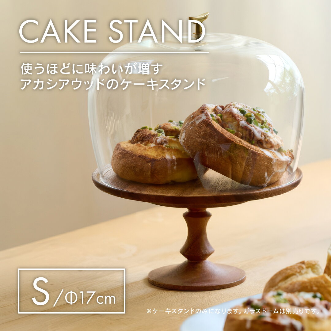 天然木のぬくもりで、 いつものスイーツを特別な一皿に。 天然木アカシアの豊かな木目を生かした、シンプルでおしゃれな木製ケーキスタンド。 ケーキや焼き菓子をのせるだけで高さが生まれ、 カフェやパティスリーのような華やかなテーブルコーディネートを楽しめます。 誕生日や記念日のホールケーキはもちろん、 マフィン、スコーン、クッキーなどのお菓子を盛り付ける コンポートやケーキプレートとしてもおすすめです。 ●天然木アカシアならではの美しい木目 アカシア材は、明るいブラウンから深みのある濃い色まで、 一枚の木の中でも豊かな色の濃淡を楽しめる天然素材。 木製ならではのやわらかな雰囲気が、 ケーキや焼き菓子の色合いを引き立てます。 ナチュラル、北欧、アンティーク、ヴィンテージ、 韓国インテリア、カフェ風など、さまざまなテイストの食卓や インテリアに合わせやすいデザインです。 ●高さを出して、テーブルを華やかに 脚付きのケーキスタンドは、平らなお皿とはひと味違った特別感が魅力。 テーブルに高さが生まれることで、ケーキやスイーツが 自然と目を引き、おもてなしの食卓を華やかに演出してくれます。 ホームパーティーや誕生日会、クリスマス、 記念日などのイベントにはもちろん、 いつものティータイムにも気軽に取り入れられます。 ●4号・5号ケーキに合わせて選べる2サイズ 用途に合わせて選べるS・Lの2サイズをご用意しました。 ⇒ケーキスタンド Lサイズはこちら ●スイーツ以外のディスプレイにも 使い方はケーキスタンドだけではありません。 アクセサリー、腕時計、香水、お気に入りの雑貨などを飾る ディスプレイスタンドとしてもお使いいただけます。 玄関やリビング、ドレッサー、ショップディスプレイなどで、 小物を少し高さをつけて飾りたいときにもおすすめ。 シンプルな木製デザインだからこそ、飾るものを選ばず幅広く活躍します。 ●別売りのガラスドームと組み合わせても 別売りのガラスドームを組み合わせれば、 ケーキや焼き菓子、お気に入りの小物を包み込むようにディスプレイできます。 木製ケーキスタンドと透明感のあるガラスの 組み合わせは相性がよく、カフェやショップのような雰囲気に。 食卓のおもてなしからインテリアまで、 暮らしのさまざまなシーンで楽しめます。 ⇒リューズガラスのガラスドーム S・Lはこちら 【 こんな方におすすめ 】 ・おしゃれな木製ケーキスタンドをお探しの方 ・4号のホールケーキを飾りたい方 ・ケーキプレートやコンポートをお探しの方 ・焼き菓子やデザートをおしゃれに盛り付けたい方 ・天然木やアカシア材の食器がお好きな方 ・北欧、ナチュラル、アンティーク、 カフェ風インテリアがお好きな方 ・アクセサリーや雑貨のディスプレイ台をお探しの方 ★プレゼント包装承ります(無料) クリスマス・誕生日プレゼント・結婚祝い・新築祝い 引越し祝い・送別品・出産祝い・記念日・退職祝い 母の日・父の日・内祝いなど、日頃の感謝やギフト、 景品におすすめです。 ※ご注文時、備考欄にラッピング希望の旨をご記載ください。 【おすすめのインテリア雑貨】 ■ アカシアウッドのケーキスタンド L ■ リューズガラスのガラスドーム S・L ■ 壁掛けミラー オーバルミラー エッジング ■ 壁掛けミラー ラウンドミラー エッジング ■ ペーパータオルホルダー　グレー ブラック ■ ピケ ウォールブラスシェルフ ■飾っても楽しめるBRASSトッパー キャンドル・バード 商品名 アカシアウッドのケーキスタンド S Acacia wood cake stand S サイズ 上部直径 約 17 × 高さ 約 9cm 重さ：約 168g 材質 アカシア ※ポリウレタン塗装 ご注意点 ●木製品はキズがつきやすく、気候・環境の変化などにより収縮や反り、多少の割れ目が生じる場合があります。 ●天然木のため、浸け置き洗いはお避けください。変形・割れ・ひびが入る原因になります。 ●使用後はできるだけ早く洗い、柔らかい布などで水気を拭き取り、よく乾燥させてください。湿ったままにしていると、カビや細菌の発生原因となりますのでご注意ください。 ●直射日光の当たる場所や火のそばなど、長時間熱が加わる場所での使用・保管はお避けください。ひび割れの原因となる場合があります。 ●表面には、風合いや手触りを損なわないよう必要最小限のコーティングを施しています。そのため、多少の色ムラが見られる場合があります。 ●使用後は放置せず、すぐに中性洗剤で洗ってください。洗い終わったら水分を拭き取り、自然乾燥させてください。 ●木の艶が失われたときは、オリーブオイルなどの植物性オイルを含ませ、木の表面に薄く塗り伸ばし、風通しの良い日陰で乾燥させてください。お手入れすることで木目を美しく保ち、長くお使いいただけます。 ●食洗機・電子レンジ・冷蔵庫は使用できません。破損の恐れがあります。 販売元 株式会社志成販売 TEL:06-6264-6489 広告文責 株式会社ディーエムエー TEL:0120-947-057 製造国 中国天然木アカシアの美しい木目と、あたたかな風合いを楽しめる木製ケーキスタンド。 ケーキや焼き菓子、デザートをのせるだけで、高さが生まれ、 いつものテーブルをおしゃれに演出します。 Sサイズは上部直径約17cmで4号ケーキに対応。 誕生日や記念日のホールケーキはもちろん、 焼き菓子やスイーツを盛り付けるケーキプレート、 コンポートとしてもおすすめです。 ケーキスタンドとしてだけでなく、アクセサリーや時計、 お気に入りの雑貨を飾るディスプレイスタンドとしても活躍。 ナチュラル、北欧、アンティーク、カフェ風など、 さまざまなインテリアになじみます。 別売りのガラスドームと組み合わせれば、 ケーキや焼き菓子、小物をより印象的にディスプレイできます。 このページはアカシアウッドのケーキスタンド「Sサイズ」です。 ⇒「Lサイズ」はこちらから アカシアウッドのケーキスタンドと合わせて使うのもおすすめ ⇒ リューズガラスのガラスドーム S・Lはこちら アカシアウッドのケーキスタンド Lサイズはこちら ⇒「アカシアウッドのケーキスタンド Lサイズ」 画像で使用のガラスドームはこちら ⇒「リューズガラスのガラスドーム」 おすすめのインテリア雑貨 アカシアウッドの ケーキスタンドLサイズ リューズガラスの ガラスドーム S・Lサイズ 壁掛けオーバルミラー ウォールミラー エッジング 壁掛けラウンドミラー ウォールミラー エッジング ペーパータオルホルダー グレー ブラック 飾っても楽しめるBRASSトッパー 誕生日