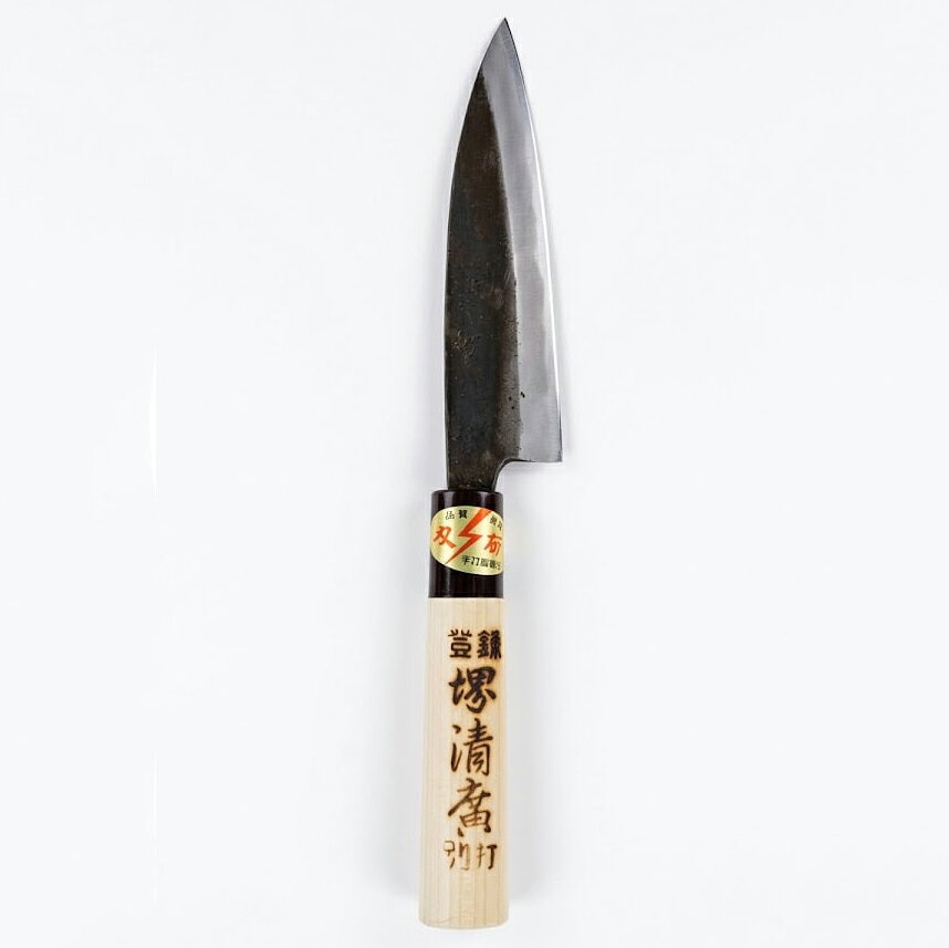 ■製品特徴 金物の産地で造られた手づくり包丁です。 ※商品の種類によっては兵庫県小野市とは別の金物の産地で造られた包丁の場合がございますが、すべて日本製です。 ■種類・サイズ 黒打、手打、両刃 135mm刃 ※クッション材（プチプチ）と新聞を使って簡易梱包でお届けします。 ◆よくある質問◆ ＜どの包丁を選べばいい？＞ 【片刃か両刃か？】 家庭用として、多くの人に使われているのは両刃ですが、正確に真っ直ぐ均一に切りたい食材は少し苦手です。 ですので、魚をおろす時、大根の桂むきなどには片刃がおすすめです。 【刃の種類の違いは？】 家庭用として、多くの人に使われているのは錆びにくいという理由からステンレスですが、切れ味を求める場合には鋼(はがね)がおすすめです。 鋼の種類は、 青鋼は硬くてよく切れるのでプロの職人さんに好まれています。ですが、粘りが少ないため扱いに慣れていないと欠けさせてしまう材質でもあります。 鋼の包丁を初めてお使いになられる場合には、 黒鋼か、さらに粘りのある白鋼がおすすめです。 この他に、 ステンレスの本体に鋼の刃がついている『割り込み鋼』は錆びにくくよく切れると人気があります。 広告文責：株式会社ドラッグピュア 作成：202609SN 神戸市北区鈴蘭台北町1丁目1-11-103 TEL:0120-093-849 販売会社：仁村金物店 区分：刃物・日本製 ■ 関連商品 仁村金物店　お取扱い商品 小刀
