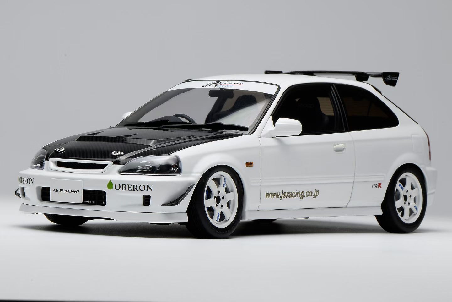 ●スケール：1：18　ダイキャストモデル ●メーカー：MotorHelix ●Hondaが誇る名車「Civic Type R（EK9）」をベースに、チューニングブランドJ's Racingのコンプリートカー仕様を1/18スケールで精密に再現。 特徴的なカーボンボンネットや大型リアウイング、ホワイトホイール、J's Racingのロゴを配したシンプルかつレーシーなリバリーは、ストリートとサーキットを両立する同ブランドの哲学を象徴する仕上がり。 クリーンなホワイトボディとの組み合わせが、スポーツモデルとしての存在感を一層際立たせています。 本モデルは、ドア・ボンネット・リアハッチの開閉機構を搭載。エンジンルームには、B16B VTECエンジンをはじめ、インテークや補強パーツ、補機類まで精巧に再現されており、1/18スケールならではの高密度なディテールを楽しむことができます。 ステアリングと前輪の連動機構も備え、実車さながらのリアリティを実現しています。