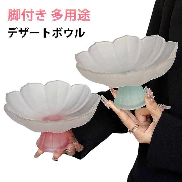 花びらの輪郭がかわいらしいすりガラス製の脚付きプレートです。曇りガラスの柔らかい質感が優しく上品な雰囲気を演出し、どんなテイストのお部屋や食卓にも自然に馴染みます。上部の皿本体は半透明のすり加工で光が優しく透け、グラデーションのような淡いカラーが繊細で可愛らしく、テーブルコーデのアクセントになります。花びらの凹凸デザインにより立体感があり、シンプルながら存在感があります。脚付き設計のメリットは、底がテーブルに触れないため汚れにくい点。手で持ちやすく、テーブルを傷つける心配もありません。多用途で活用できる実用的な雑貨です。和菓子・クッキー・キャンディーなどの菓子皿、ベリーやぶどうといった小さなフルーツ皿としてはもちろん、玄関の鍵置き、洗面台のピアス・指輪などアクセサリートレイにも最適。カフェ風インテリア、ナチュラルなお部屋にぴったりです。厚みのあるガラス素材で丈夫で割れにくく、水洗いが簡単。汚れが落ちやすくお手入れの手間が少なく、毎日気軽に使えます。お茶タイムのおもてなしはもちろん、インテリアの飾り皿としても映えます。 サイズ F サイズについての説明 口直径約17cm/高さ約9cm/底部直径約6.3cm　※80℃まで対応　※サイズ表の実寸法は商品によって1-2cm程度の誤差がある場合がございます。　 素材 ガラス 色 ピンク ブルー グリーン イエロー 備考 ●サイズ詳細等の測り方はスタッフ間で統一、徹底はしておりますが、実寸は商品によって若干の誤差(1cm～3cm )がある場合がございますので、予めご了承ください。 ●製造ロットにより、細部形状の違いや、同色でも色味に多少の誤差が生じます。 ●パッケージは改良のため予告なく仕様を変更する場合があります。 ▼商品の色は、撮影時の光や、お客様のモニターの色具合などにより、実際の商品と異なる場合がございます。あらかじめ、ご了承ください。 ▼生地の特性上、やや匂いが強く感じられるものもございます。数日のご使用や陰干しなどで気になる匂いはほとんど感じられなくなります。 ▼同じ商品でも生産時期により形やサイズ、カラーに多少の誤差が生じる場合もございます。 ▼他店舗でも在庫を共有して販売をしている為、受注後欠品となる場合もございます。予め、ご了承お願い申し上げます。 ▼出荷前に全て検品を行っておりますが、万が一商品に不具合があった場合は、お問い合わせフォームまたはメールよりご連絡頂けます様お願い申し上げます。速やかに対応致しますのでご安心ください。