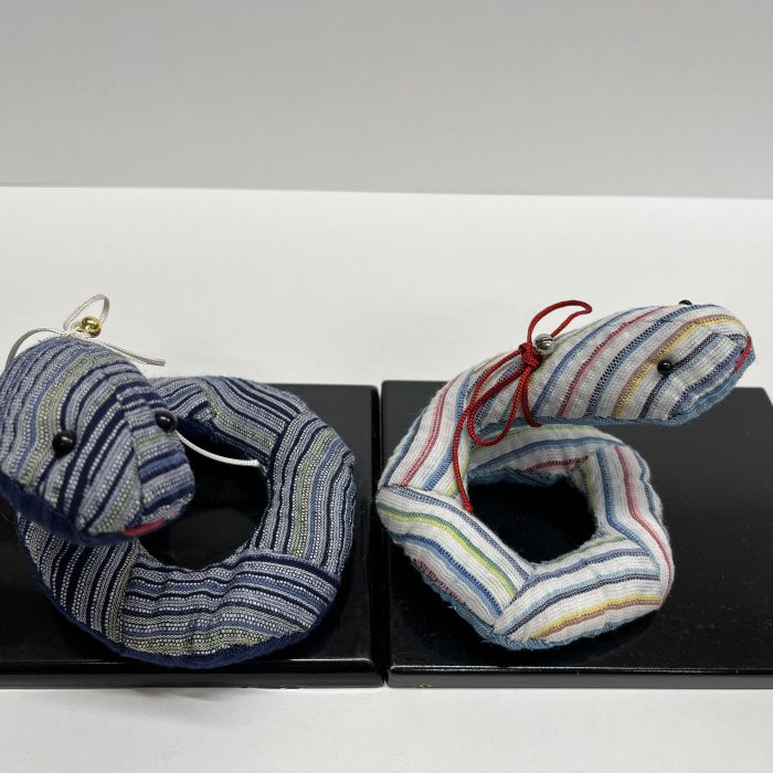 しじら織の三角ピースをつなぎ、くるりと巻くように仕上げる巳のペア。 ワイヤー入りなのでお好みの形に飾れます。 サイズ：大　高さ9cm×幅12cm、小　高さ7cm×幅9cm キット内容：しじら織、刺繍糸、目玉ボタン、ワイヤー、ひも、鈴 詰め綿は別にご用意ください。