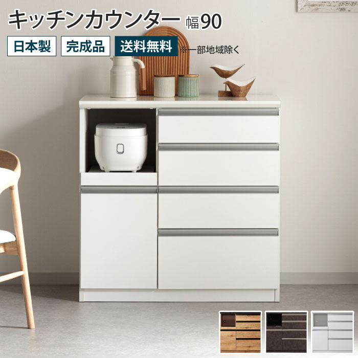 ■商品説明 キッチンカウンター 幅90（幅89.4cm） デザイン性と機能性を備えた高機能キッチンカウンター 毎日使うキッチン家電や小物をまとめて収納できる大容量の収納力。気になる生活感を隠して見た目も使い勝手もスマートに。 ・熱や汚れに強く、指紋のつきにくい天板 天板は、傷や熱に強く耐久性に優れ、汚れをさっと拭き取れる石目調ダップ化粧板（ナチュラル・ブラウン）、鏡面メラミン化粧板（ホワイト）を採用しました。 ・ゆっくり閉まる引き出しと扉収納 引き出しは、奥まで開くことができ、閉まる手前で衝撃を和らげゆっくり閉まる、ハーフェレ製ソフトクローズレールを全段に採用しました。 また、扉収納にもゆっくり閉まるソフトクローズ丁番を使用しているので、扉が勢いよく閉まる心配がありません。 ・家具や家電に優しいモイス材を使用したオープン収納部 オープン収納部は引き出して使えるスライドテーブルになっています。上部には天然素材のモイスを使用しており、家電から出る蒸気を吸収・蓄湿・放湿を繰り返し家具を守ります。また、背面に配線コード穴付きでコード類もすっきりまとまります。 ・どこから見ても美しい背面化粧仕上げ 背面も表面や側面と同じ柄で仕上げています。壁に寄せるだけでなく、リビングとダイニングの間仕切りにしたり自由にレイアウトできます。 ■サイズ 約 幅89.4cm×奥行48cm×高さ90cm ■材質 天板：石目調ダップ化粧板（ナチュラル、ブラウン）/鏡面メラミン化粧板（ホワイト） 本体：MDF、パーティクルボード、強化紙（ナチュラル）、塩ビ（ブラウン）、鏡面ハイグロス（ホワイト） ■製造国：日本 ■仕様：完成品 ■備考 ・天板耐荷重：約40kg ・接着剤、合板：F☆☆☆☆（エフフォースター） ・繊維板：F☆☆☆(エフスリースター) ・ハーフェレ製ソフトクローズレール ・開扉ソフトクローズ ・モイス材 ・裏面化粧仕上げ ■ご注意 ※こちらの商品は「軒先渡し」となります。オプションで開梱設置サービスがございます。ご希望の場合は、開梱設置オプションのプルダウンにて「希望する」をお選びください。 ※表示のサイズは商品により多少の誤差を生じることがございます。 ※配送できず返品となった場合「往復の送料」「再梱包費用」をご請求させて頂きます。搬入経路を必ずご確認ください。 ※一部地域は別途送料を頂戴いたします。 ※コーディネートイメージは、お使いのモニターやPCの環境、お部屋の光の加減などにより、実際の商品と色味等が異なって見える場合がございます。 ※商品のイメージの違いによる、ご返品・交換は原則としてお断りしておりますので、ご了承ください。 ※商品の仕様は予告なく変更になる場合がございます。【レビューキャンペーン商品202306】※現在ご覧のこちらのページからは、＜キッチンカウンター 幅90（幅89.4cm）＞がご購入いただけます。 幅90（幅89.4cm） 幅120（幅119.4cm） 幅140（幅139cm）