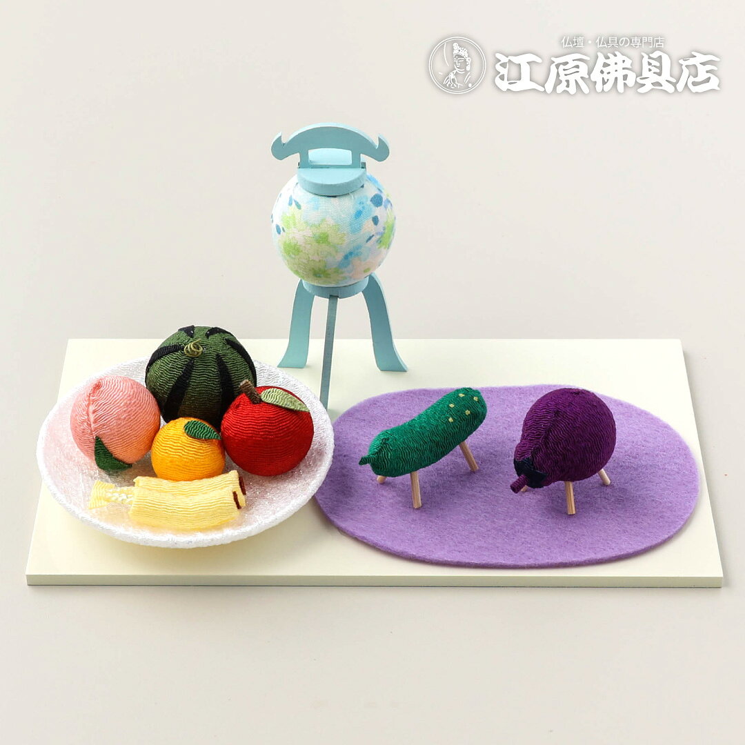 サイズ ・提灯：幅 約4cm 奥行 約4cm 高さ 約8.5cm ・台：幅 約18.7cm 奥行 約10.5cm 高さ 約0.5cm ・フェルト（藤色） 幅 約11cm 奥行 約7.6cm ・きゅうり（馬）：幅 約4.8cm 奥行 約1.5cm 高さ 約2.2cm ・なす（牛）：幅 約4cm 奥行 約3cm 高さ 約3.4cm ・くだもの皿：直径 約8.5cm 高さ 約1.0cm 素材 レーヨンちりめん・綿布・天然木・他 商品説明 やさしい色合いに心が和む、ちりめん細工のお盆飾りセットです。 ころんと可愛い精霊馬と上品なパステルカラーの盆提灯がお盆の空間を明るく華やかに彩ります。 職人がひとつひとつ丁寧に手作りしているため、それぞれ表情や花柄の出方が異なるのも魅力。 コンパクトサイズなので、リビングや玄関、仏壇まわりに飾りやすく、初めてのお盆飾りにもおすすめです。 「ご先祖様を優しくお迎えしたい」そんな想いに寄り添う、ほっこり可愛いお盆用品。 伝統的なお盆飾りを現代のお部屋にも馴染むパステルデザインで楽しめます。 お盆のひとときを、やさしく彩る癒しの飾りです。 ・ちりめん素材の優しい風合い ・可愛い精霊馬と果物飾り付 ・省スペースで飾りやすい ・贈り物や新盆のお供えにもおすすめ ・手作りならではの温かみある仕上がり ※パステル盆提灯は職人が1つ1つ手作りしている為、花柄の出方が異なります。 柄の出方は選べませんのでご了承下さい。