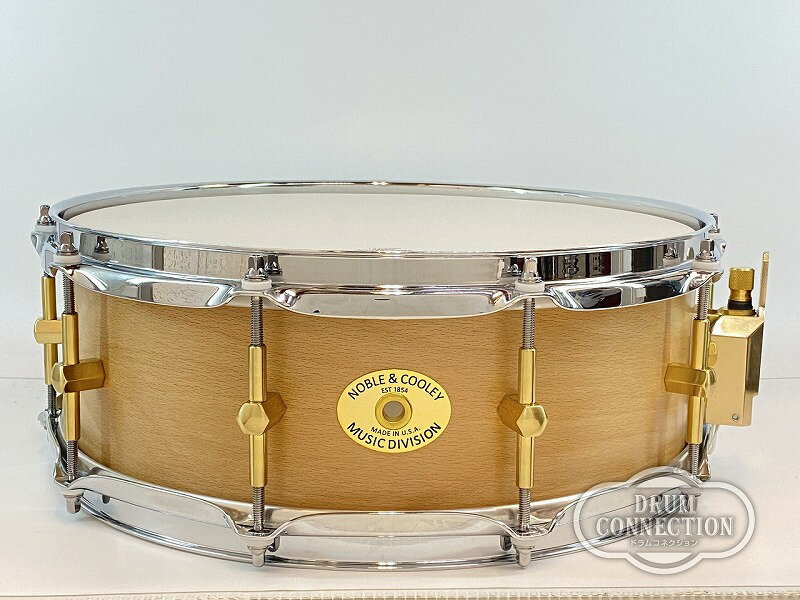 当店が正規輸入代理店を行っているドラムブランドNoble & Cooleyから、SS Classic Solid Beech 14"×5"が入荷致しました。 【Noble & Cooley】 アメリカの職人によるハンドメイドドラムブランドであるNoble & Cooleyは、常に製造方法を製錬し続けながらドラムを作り続けて150年になり、世界で最高のドラムを作るためにこの得意分野を追求し続けています。 ニューイングランド地方の最高品質の木材を使用し、完璧なドラムを届けるために最新の注意を払って精巧に作り上げています。 〜製造工程〜 Noble & Cooleyでは、マサチューセッツ州グランビルの工場で手作業で製造を行っています。 木材の選定・シェルのデザイン設定から金属部品の選定・フィニッシュ加工まで、最高のサウンドと美しいルックスにこだわり製造しています。 値段が高めに設定されている理由はクオリティによる違いだけでなく、特別なものに仕上げるためのコストを要するからです。 お客様の音楽にすぐに溶け込むことができ、生涯を共にしたいと思うような、ユニークで特別でお客様が自慢したがるようなドラム。 そんなあなただけのドラムを届けることが、Noble & Cooleyの信念です。 〜SS Classic〜 多くのプロドラマーのレコーディングにも使用されている、最高級単板シェルのスネア。 そのサウンドは優雅でリッチなキャラクターと完璧な胴鳴りが組み合わさった逸品。 Noble & Cooleyの名を世界中に轟かせた代表的なシリーズです。 〜スタッフコメント〜 落ち着いた温かみのある木目に、単板ならではのパワフルかつ中低音の効いたサウンドで、ビーチの良さを存分に感じる一台です。 また、ブラスで作られたラグやパーツが上品なサウンドに仕上げ、嫌な倍音もきれいにまとめらています。 ミドルレンジのチューニングもよくまとまり、ミックスをかけたようなサウンドを演出。低音を効かせたい、ロックやPOPS等に使う時に存分に力を発揮出来るスネアです。 〜スペック〜 サイズ:14"×5" フィニッシュ :Natural Oil シェル:Solid Beech+Beech RF フープ:2.3mmトリプルフランジフープ スナッピー:CAM ACTION WIRE Noble & Cooley ※こちらの商品は撮影後、店頭展示かつ試打を解禁しておりますため、打痕や指紋、展示による細かい傷などがある場合がございます。予めご了承下さいませ。 ※こちらの商品は店頭にて写真撮影を行っているため、実際の商品と若干色味が異なる場合がございます。予めご了承くださいませ。 ※掲載商品売却の際、迅速にサイトから削除するよう心がけておりますが、 ショッピングページの更新にタイムラグが生じる場合がございます。 万一ご注文後に売切れとなっておりました場合は、誠に恐れ入りますがご容赦ください。 詳しい在庫状況は下記連絡先までメールかお電話にてお問い合わせください。 担当:川崎 ------------------------------------------------------------------------ クロサワ楽器お茶の水ドラムコネクション 〒101-0062 東京都千代田区神田小川町3-22 e-mail : drum-c@kurosawagakki.com Tel : 03-3292-9251 ------------------------------------------------------------------------