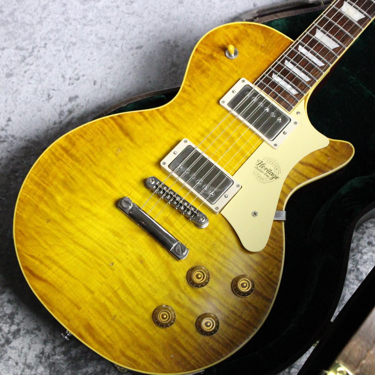 225 Parsons Streetにて1917年から楽器製造を続ける伝統の工場にて作られる"Heritage"の名に相応しいギター！ それがこのH-150です。 会社は変われど伝統的な製法を失う事なく今日まで伝えるエレキギターの歴史の中でも非常に重要な工場です。 ヘリテージ・ギターは今もなお、伝統的な製法によってこの地でギターを作り続けています。 American Handmade 伝統を引き継ぐクラフトマンシップ 最良の木材を用いたアメリカンハンドメイド ・50年代黄金期の職人が引き継ぐ「オリジナル」 ジム・デュローを中心に、50年代の黄金期を支えた複数の職人がオリジナルのアメリカン・ハンドメイドギターを現代に引き継ぎました。 ・地元ミシガン州産のイースタンメイプルを使用 米国東部に位置するミシガン州で採れるメイプル材は耐久性が高く、クリアな音色と、特に低音域のレスポンスが良いことが特徴です。 ・良質なジェニュイン・マホガニーへのこだわり スタンダードのH-150にも一枚板のジェニュイン・マホガニーを使用。 完全ソリッドボディへのこだわりは、伝統のクラフトマンシップの表れです。 今回入荷のモデルはHeritage Custom Shopの中核となるCore Collectionの一本です。 施されたAged加工はクラックの入り方から打痕一つまで非常にリアルに仕上がっており、"Artisan"＝"職人"の名の通りの貫録を見せつけてくれます。 ボディバックにも同様のAgedが施されており重厚な雰囲気を醸し出しております。 Darty Lemon Burst x Aged加工。褪色したバーストとエイジド加工の組み合わせが王道の風格を魅せる1本となっております。 ボディバックとネックに使われるGenuine MahoganyはGenuine(純正品)が表す通り、近縁種等ではなく北米から中南米にかけて分布するマホガニーを採用。 塗装はヴィンテージ特有の艶を持つCore Collection用に開発されたニトロセルロースラッカー塗装を採用。 新品時の濡れたような艶を持つ上品さから経年変化により見せる貫録のある表情まで変化していく生きた塗装とさえ言えます。 独自のヘッドストックは先端に向かうほど幅が狭くなり、ナットで弦が曲がる角度を浅くしチューニングの安定が増すよく考えられた形状となっております。 中央にはCustom Shopのみ採用されるダブルアローインレイを配置が配置されております。 PUには新たに開発された255 Classic Humbuckerが搭載。 カラマズー工場の番地、「225」を冠したこのPUはCustom Shopのみに搭載されるものとなっており、 ゲインは低めのためピッキングのニュアンスからVol、Toneの操作に敏感に反応し、ローエンドに太さが存在するためパワー感も充分ございます。 弦振動を余さず捉えピッキング一つで張り詰めた高音域が際立つロックトーンから、甘く柔らかく響くジャジーなトーンまでリニアに変化させることができます。 サウンド面もくっきり立ち上がるハイがまず印象として感じられます。 もちろん当モデルに期待するローの厚みや艶、図太さは当然備えており、先述の立ち上がりと合わせヌケる図太い音となり多くの方が求めるサウンドをまさに体現してくれます。 ぜひこの機会にご検討くださいませ。 Body Material: Select Curly Maple (Top) / Ultra-Light Genuine Mahogany (Back) Body Color: Ebony Body Finish: Nitrocellulose, Vintage Gloss Fretboard Material: Rosewood Fretboard Radius: 12" Fret Size: Jescar Medium/Jumbo Nut Material: Bone Neck Profile: '50s C (.8910" ? .9805") Neck Material: Genuine Mahogany Scale Length: 24-3/4" No. of Frets: 22 Fretboard Inlays: Acrylic Trapezoid Headplate: Pearl 'Heritage' Logo and Custom Shop Motif Pickups: Heritage Custom Shop 225 Classic Humbuckers (Neck & Bridge) Controls: 2 x Volume, 2 x Tone, 3-Way Toggle Electronics: Custom CTS Potentiometers, Orange Drop .022uF Capacitors, Switchcraft Toggle Switch and Switchcraft Input Jack Bridge: Locking Tune-O-Matic Tailpiece: Aluminum Stopbar Pickguard: Plastic Tuning Machines: 'Heritage' Branded Tuners Hardware Finish: Nickel Control Knobs: Gold Top Switch Tip: Amber 付属品:Hard Case、正規保証書 ※撮影機材の性能や、お使いの画面環境によって実物と色味が異なって映ることがございます。 予めご了承をお願いいたします。 【選べる豊富な決済方法】 クレジットカード決済/銀行振込/代引き/ショッピングクレジット --------------- 【ショッピングクレジット無金利＆超低金利キャンペーン】 48回払いまで金利手数料0%!!　 [ 54回 1%／60回 2% ／84回 5% ] ※各種分割払い(クレジットカード、ショッピングクレジット)ご利用いただけます。 詳しくはお電話もしくはメールにてお気軽にお問合せくださいませ。 --------------- 【買取・下取り、試奏、ご購入を検討の方】 (株)黒澤楽器店 お茶の水駅前店新館1F 東京都千代田区神田駿河台2-2-2 TEL：03-3293-5625 MAIL：eki@kurosawagakki.com 営業時間:11:00〜20:00(年中無休) ---------------