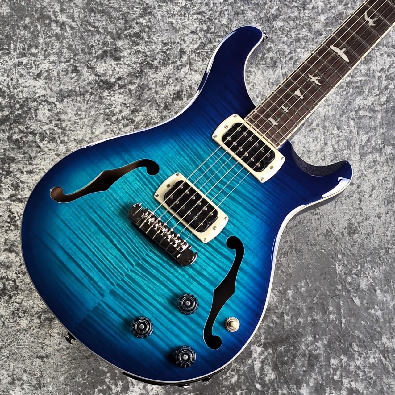 ヴィンテージギターからインスパイヤを受け、それらの融合を目指したPaul Reed Smith。 最初期からサンタナを始めとする有力アーティストから支持を受け、現在ではトップギターブランドに君臨する同社のセミホロウモデルがお求めやすい価格にて入荷いたしました。 SE(Student Edition)という廉価シリーズながら同モデルの特徴となるプレイアビリティの良さとサウンドバリエーションの豊富さをしっかり継承したモデルとなっております。 こちらはブリッジにピエゾピックアップを搭載した、よりアコースティック色の強いモデルとなっております。 公式サイトより Powerful Versatility PRS SE Hollowbody I Piezoは、普段ソリッド・ボディのエレクトリック・ギターをメインに演奏しつつも、ホロウボディ特有の深みのある響きを求めるギタリストに向けてデザインされ、メイプル・トップ、マホガニー・バック、そしてセンター・ブロックを用いたフルホロウ・ボディ構造を採用し、サステインや フィードバック・コントロールを損なうことなく広がりのあるトーンを生み出します。 搭載されているピックアップ85/15 “S”は、レンジが広く低音域から高音域までバランスの取れたトーン特性を持ち、マグネティック・ピックアップ用とピエゾ・システム用の独立したボリュームを搭載することで、各ピックアップ単体のサウンドだけでなく、両サウンドをブレンドした多彩なサウンド・メイキングが可能です。 パンチのあるアタック感と豊かなサステインを兼ね備え、音楽的かつ倍音豊かなサウンドを生み出す本モデルは、リズム・ワークからソロ・プレイまで幅広く対応し、25インチ・スケールのワイド・ファット・シェイプのネックは、長時間の演奏においてもストレスのない快適なプレイヤビリティを実現しました。 PRS Adjustable 'Piezo' Stoptail 6つの独立したピエゾ・サドルを備えたこのブリッジは、L.R. BaggsとPRSが共同で開発した独自のピエゾ・エレクトロニクスと連携し、1本のギターでエレクトリックサウンドとアコースティックサウンドをスムーズに切り替えることが可能。 PRS-Designed Tuners PRSオリジナル・デザインのチューニング・ペグ。高精度かつ安定したチューニング性能を実現。 PRS 85/15 “S” 低音域から高音域までバランスよく押し出すPRS独自設計のピックアップ。 クラシックからモダンなジャンルまで幅広いサウンドをカバー。 Flatback Design Hollowbody Iでは、よりエレクトリック・ギターに近い快適な演奏性を実現するため、コンター加工を施したスリムな“Flatback”デザインを採用。これにより、ホロウボディ特有の広がりと立体感のある豊かなサウンドを実現しています。 SPECIFICATIONS BODY Body Construction : Hollowbody, Flatback Top Wood : Maple Veneer : Flame Maple Back Wood : Mahogany Top Carve : Shallow Violin Body Binding : Cream NECK Number of Frets : 22 Fret Wire : PRS Standard Fret Wire Width of Fret Crown : .104" Height of Fret Crown : .046" Scale Length : 25" Neck Wood : Maple Neck Construction : Multi-Ply Truss Rod : PRS Double-Acting Neck Shape : Wide Fat Neck Depth at the 1/2 Fret : 7/8" Neck Depth at the 12 1/2 Fret : 61/64" Neck Width at the Nut : 1 11/16" Neck Width at the Body : 2 1/4" Fretboard Wood : Rosewood Fretboard Radius : 10" Fretboard Inlay : Birds Headstock Logo : Signature "SE" Neck Binding : Cream HARDWARE Bridge : PRS Adjustable Stoptail Piezo Tuners : PRS Designed Tuners Hardware Type : Nickel Nut : PRS Truss Rod Cover : “Hollowbody” ELECTRONICS Treble Pickup : 85/15 “S” Bass Pickup : 85/15 “S” Controls : Magnetic Volume, Piezo Volume, Tone Control & 3-Way Toggle Pickup Switch ADDITIONAL INFO Strings : PRS Classic 10-46 Tuning : Standard (6 String): E, A, D, G, B, E Case : Gig Bag ※撮影機材の性能や、お使いの画面環境によって実物と色味が異なって映ることがございます。 予めご了承をお願いいたします。 【選べる豊富な決済方法】 クレジットカード決済/銀行振込/代引き/ショッピングクレジット --------------- 【ショッピングクレジット無金利＆超低金利キャンペーン】 48回払いまで金利手数料0%!!　 [ 54回 1%／60回 2% ／84回 5% ] ※各種分割払い(クレジットカード、ショッピングクレジット)ご利用いただけます。 詳しくはお電話もしくはメールにてお気軽にお問合せくださいませ。 --------------- 【買取・下取り、試奏、ご購入を検討の方】 (株)黒澤楽器店 お茶の水駅前店新館1F 東京都千代田区神田駿河台2-2-2 TEL：03-3293-5625 MAIL：eki@kurosawagakki.com 営業時間:11:00〜20:00(年中無休) ---------------