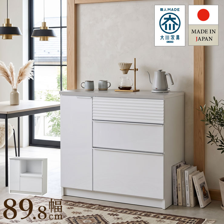 ■商品番号：88-000075 【この商品のスペック】 ■寸法 本体：幅89.8×奥行41.1×高さ90cm ※天板耐荷重：約20kg ■素材 天板：ガルバリウム鋼板 本体：プリント化粧板 前板：塩ビシート（艶有）真空貼り、MDF18mm 取っ手：アルミ取手 レール：フルスライドレール ■梱包サイズ 約幅91.5×奥行43×高さ92cm ■商品の特徴 毎日使うキッチンだから、見た目も使い勝手も心地よく。クールスは、清潔感のあるホワイトの本体に、落ち着いたグレージュカラーのガルバリウム鋼板天板を合わせた日本製キッチンカウンターです。 天板は水や汚れに強く、マグネットを取り付けられるため、フックや小物収納を使ったアレンジも可能です。 幅90cmタイプは、炊飯器などの家電を置きやすい「OPタイプ」と、食器やストックをたっぷり整理できる「引き出しタイプ」の2種類。 引き出しには奥まで見渡しやすいフルスライドレールを採用しました。 完成品でお届けするため、届いた日からすぐにお使いいただけます。 ■おすすめポイント ・水や汚れに強いガルバリウム鋼板天板 ・天板にマグネットを取り付け可能 ・空間に馴染むホワイト×グレージュ ・奥まで引き出せるフルスライドレール ・手を掛けやすいアルミ取っ手 ■備考 日本製（大川家具）、完成品 照明やモニター環境の違いにより写真の色とは多少異なる場合があります。予めご了承ください [_kitchenmicrowave_][_kitchencounter_]水や汚れに強いガルバリウム鋼板天板と、空間に馴染む清潔感のあるデザイン。クールス 89.8cm オープンタイプ/引き出しタイプ商品番号：88-000075