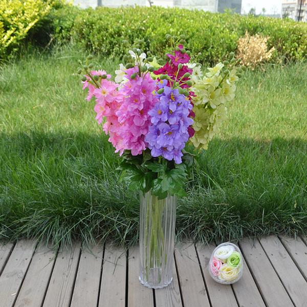人工絹のデルフィニウムの花緑色植物の家の装飾を残します