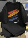 背中に赤、オレンジ、紫などのカラフルな筆文字と文字が入った200gの黒Tシャツ。トレンディでアーティスティックなデザインで、リラックス・フィット。