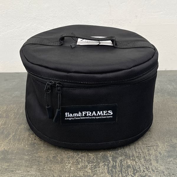 flame FLAMES 卓上でも使える日本製ミニ七輪の収納バッグ バーベキュー・アウトドアにSHICHIRIN STRAGE BAG：七輪専用ストレージバッグ（ラウンド型）「SHICHI-RIN ROUND」専用ケースです。七輪本体がそのまますっぽり入ります。クッション性のあるケースで、本体表面を傷からやさしく守ります。ケースに入れることで、使用後の灰などの汚れも気にせず持ち運べます。「SHICHI-RIN ROUND」は黒の本体がスタイリッシュな七輪です。愛知県碧南市にて、昔と変わらぬ製法で一つずつ手作りされています。能登産珪藻土を使用しており、熱性・保温性に優れ、炭がよく保ちます。バーベキューやアウトドアはもちろん、卓上でも使用できる小型サイズ。持ち手がついており、持ち運びにも便利です。サイズ直径26.5cm、高さ17.5cm素材ポリスチレン製造国日本※耐熱素材ではありません。変形、変質のおそれがあるため七輪の粗熱をとってからご使用ください。 ※摩擦や水濡れ、密着等により色落ちや色移りが発生する場合があります。※写真はイメージです。収納バッグのみで七輪本体は付いていません。