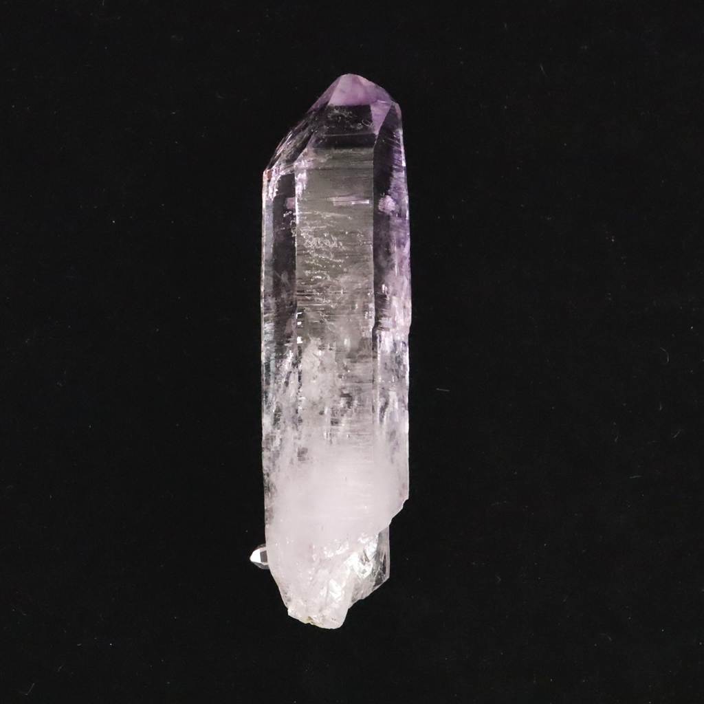 商品説明 商品名 ベラクルス州産 アメジスト 63mm結晶 原石 21.6g　(ID:59883) サイズ(mm) 17 X 63 X 13 重量 21.6g 産地 メキシコ ベラクルス州 金属部分の材質 --- コメント ◆　本商品写真は現物のものです。写真の商品をお届けします。◆　メキシコ・ベラクルス州ラス・ヴィガス鉱山産のアメジストです。この産地の特徴である、細長く伸びた結晶構造を有しています。特筆すべきは結晶の透明度で、内部のインクルージョンが少なく、クリアな質感の中に淡い紫色が発色しています。結晶側面には成長過程で形成された条線が確認でき、先端まで鋭角な形状を保っています。 ◆ エネルギー的な純度が高い石として認識され、主にクラウンチャクラへの作用が語られる種類のクリスタルです。意識をクリアにし、瞑想や内省の状態へスムーズに移行するためのサポートとして機能すると云われています。静かな環境を整えたい時や、思考を整理・リセットしたい場面に適しています。 ご注意事項 ◆　本商品は、当社運営の他WEBショップにて販売している為、在庫更新のタイミングにより、欠品が生じる可能性がございます。予めご了承のほどお願いいたします。【y8jt&yu3#s】