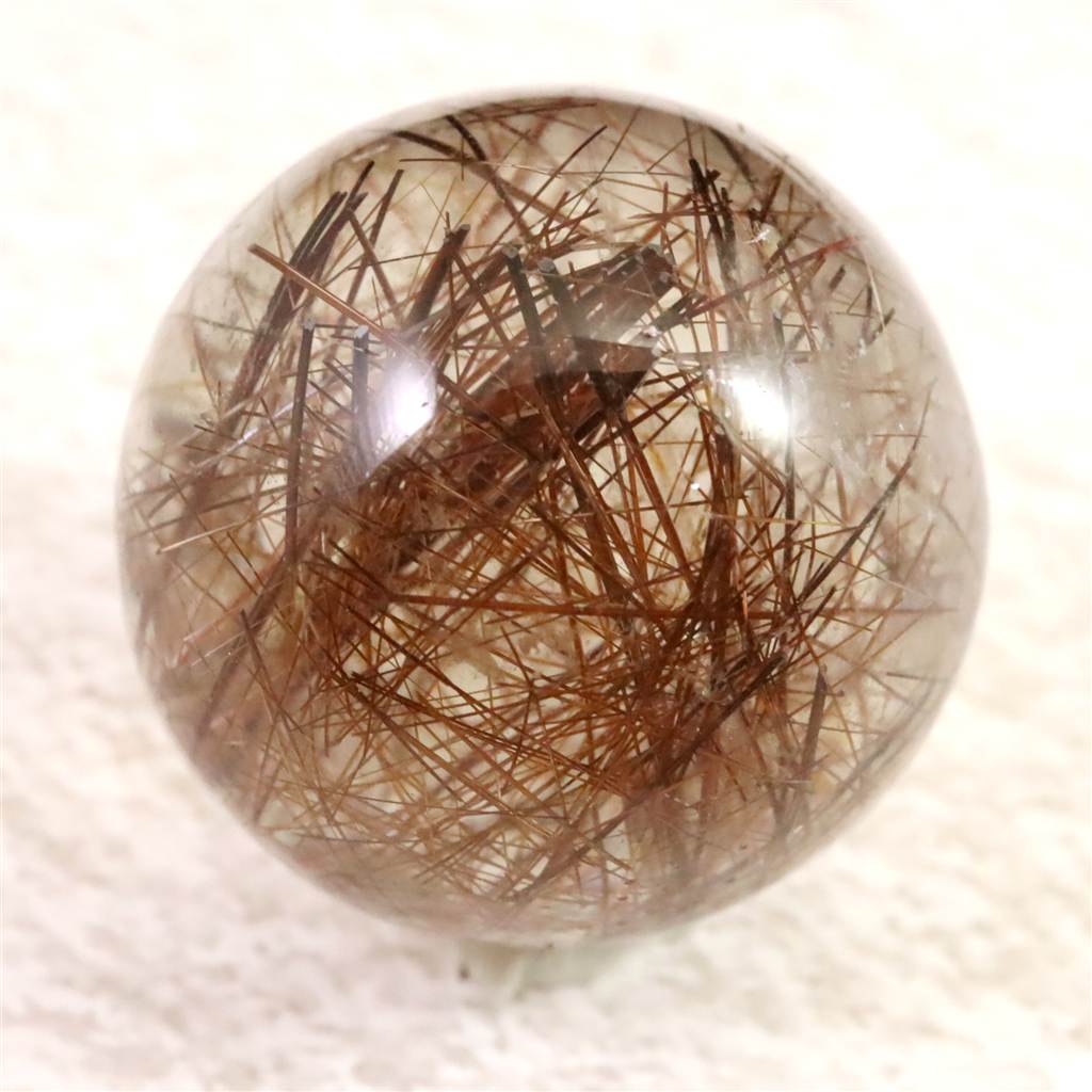 商品説明 商品名 レッドブロンズルチルクォーツ　25mmスフィア 22.1g 　(ID:86722) サイズ(mm) 直径25 重量 22.1g 産地 ブラジル 金属部分の材質 --- コメント ◆　本商品写真は現物のものです。写真の商品をお届けします。台座付です。◆　鉱物学的にはルチルレイテッドクォーツ（針入り水晶）の一種です。内包される二酸化チタン（ルチル）が鉄分を多く含むことで、深みのある赤褐色からブロンズ色に発色します。透明な水晶の中を、渋みのある金属光沢を放つ針が縦横無尽に走る様は、通常のゴールドルチルとは一味違う、重厚な高級感と力強さを漂わせます。◆　エネルギーの側面では、生命力（プラーナ）の強力な増幅装置として機能します。ゴールドが「金運」なら、この色は「具現化と行動力」の象徴です。高次のエネルギーを肉体レベルにしっかりと定着（グラウンディング）させ、やる気や情熱を再点火させると云われています。不安や躊躇を焼き払い、目標に向かって突き進むための持続的なバイタリティを授ける、実践的な守護石です。 ご注意事項 ◆　本商品は、当社運営の他WEBショップにて販売している為、在庫更新のタイミングにより、欠品が生じる可能性がございます。予めご了承のほどお願いいたします。【y8jt&yu3#s】