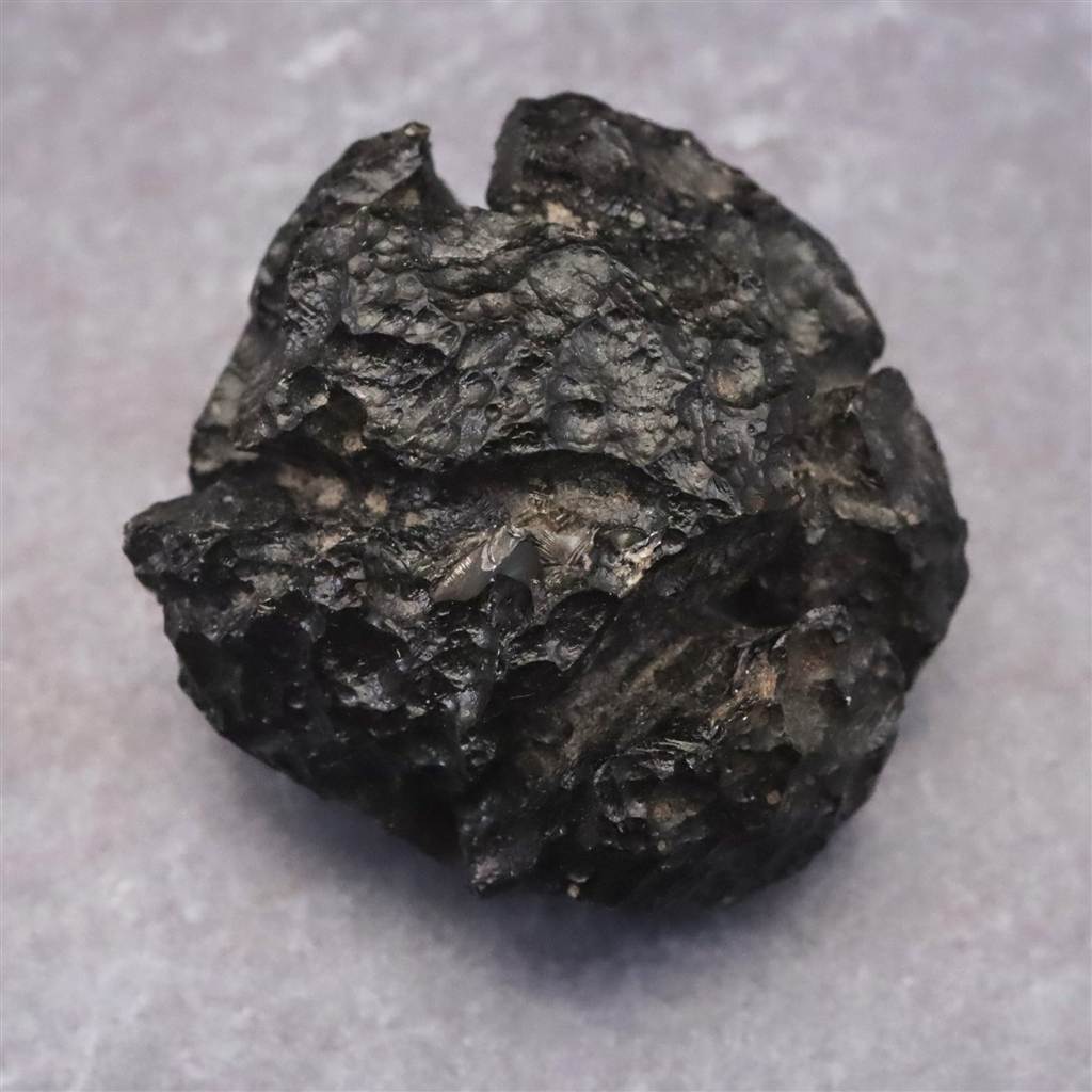 商品説明 商品名 フィリピナイト　フィリピン産テクタイト　32mm原石 25.8g　(ID:50527) サイズ(mm) 31 X 32 X 23 重量 25.8g 産地 フィリピン ルソン島 ビコル地方 金属部分の材質 -- コメント ◆　本商品写真は現物のものです。写真の商品をお届けします。◆　フィリピン最大の島であるルソン等で産出されたテキタイトです。通称フィリピナイトとも呼ばれています。◆　フィリピン諸島周辺で採取される、希少なテクタイトの一種「フィリピナイト」の原石です。テクタイトとは、約80万年前に巨大な隕石が地球に衝突した際、その絶大な熱エネルギーによって地表の岩石成分が瞬時に溶けて大気圏外へと吹き飛ばされ、再び落下する過程で急速に冷却されて形成された「隕石衝突由来の天然ガラス」を指します。フィリピナイトは広大なオーストラレーシア・テクタイト群の一部であり、原石の表面には、大気圏を飛来する際の激しい摩擦や、地層の中で長い時間をかけて化学的に風化・浸食されることで生じた特有の深い凹凸（ディンプル）や流線型の溝が刻まれているのが地質学的な最大の特徴です。 ご注意事項 ◆　本商品は、当社運営の他WEBショップにて販売している為、在庫更新のタイミングにより、欠品が生じる可能性がございます。予めご了承のほどお願いいたします。【y8jt&yu3#s】