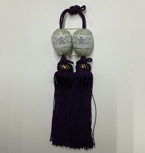 風鎮【上染付/二巴】 お好みの掛図に合わせることで、主役の掛図を一層引き立てます。陶器製のこの風鎮は、陶器部分からフサまでが約17.5cmのサイズで、掛軸の装飾に最適です。 インテリアとしても魅力的で、和の空間に優雅さを添えます。化粧箱(紙箱)入りで、大切な方への贈り物にもぴったりです。 ■詳細 房の長さ　13cm 軸先から房の下までの長さ27cm 玉のサイズ縦4×横3.0cm 玉の種類　上染付/二巴 房　紫