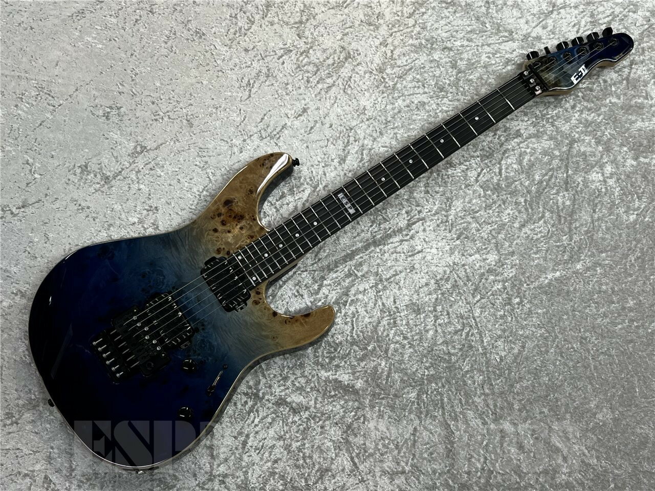 鮮やかなブルーフェード系のカラーにバールトップが際立つ美しいモデル。 フロイドローズを搭載し幅広いプレイが可能なまさに万能な一本。 また、PUには今やラウド系、モダンメタルギターでは定番となりつつある BareKnuckle AFTERMATHをセレクト。 スラッシーなリフから、テクニカルな早いパッセージまでこなすギターに仕上げました。 ■主な仕様 BODY：(Top)Buckeye Burl Maple, (Back) Alder, w/Natural Binding NECK：Hard Maple GRIP SHAPE：Thin U FINGERBOARD：Ebony RADIUS：305R SCALE：648mm NUT (WIDTH)：Locknut (42mm/R2) INLAY：Dot, 12th at ESP FRET：XJ, 24frets CONSTRUCTION：Bolt-on (STAR CUT) TUNER：GOTOH SG360-07 MG-T BRIDGE：Floyd Rose PICKUPS：(Neck) Bare Knuckle AFTERMATH Battleworn, (Bridge) Bare Knuckle AFTERMATH Battleworn PARTS COLOR：Black CONTROLS：Master Volume, Master Tone, 3WAY Lever PU Selector 重量：約3.8kg ■ギグケース付属 ■コンディション 新品 こちらの商品はESPクラフトハウス以外の店舗からの発送商品となります。 セットアップ・点検については、ESPクラフトハウス同様に行なっておりますのでご安心ください。 ※掲載商品は店舗/他のWEBサービス等と並行して販売しております。随時在庫状況の更新を行っておりますが、売り切れの場合はご了承下さい。 なお、在庫の確認につきましてはお電話・メールにてお問い合わせください。