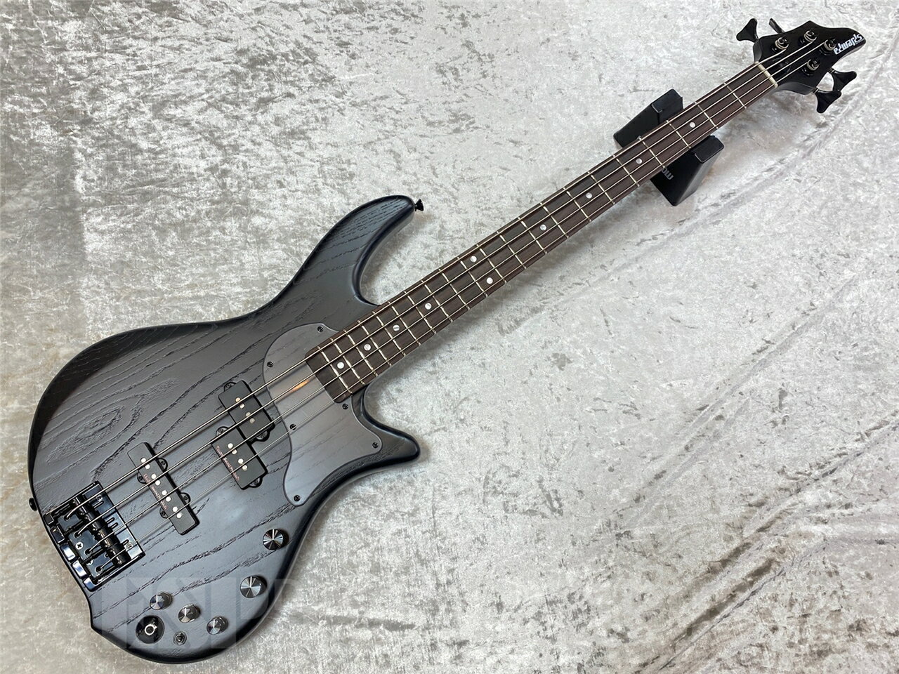 ■商品説明 ハードメイプルの明瞭でタイトなレスポンスと、ウォルナットの中低域のふくよかさが絶妙に融合。剛性にも優れ、長期間にわたる安定性を確保しています。スルーネック構造により、ボディ全体で鳴るような一体感のあるサウンドと、際立ったサステインを実現しています。ボディウイングにはアッシュ材を採用。アタック感に優れた明るいトーンを持ち、輪郭のあるサウンドをアウトプット。スルーネック構造との組み合わせにより、力強いアタックとレンジの広いサウンドを両立し、様々なジャンルに対応できる柔軟性を備えています。 コンパクトに設計されたボディシェイプは、ステージ上でも取り回しが良く、長時間の演奏でも疲れにくい設計。加えて、38mmのナット幅とスリムなネックにより、手の小さなプレイヤーでもストレスのないフィンガリングが可能。テクニカルなプレイにも対応できる快適な操作性を実現しています。 ピックアップにはESPカスタムラボ製のPタイプとJタイプのコンビネーションを搭載。存在感のあるトーンを出力しながらも、豊かな倍音と自然なニュアンスを保持。さらに、HALIBUT CustomアクティブEQ回路を内蔵し、3バンドEQによる柔軟なトーンコントロールが可能です。繊細なトーンからパワフルなサウンドまで、幅広い音楽スタイルに対応する表現力をプレイヤーにもたらします。 ブリッジには、国内外の多くのプロに信頼されるGOTOH製404-SJブリッジを採用。裏通しで弦を張る構造により、テンション感を高めつつタイトで芯のあるサウンドで、正確なピッチと安定したサスティンがを約束します。 ■特徴 ・ESP Custom Labピックアップ 特殊なアーシングを施しているESP Custom Labのピックアップは、ハムキャンセル構造ではないにも関わらず、非常にローノイズでクリアなサウンドを提供します。 ネック・ポジションに搭載されているCL-P-P-1は、たくましいミッドレンジと力強いアタックを持ち、音の濁りがないピックアップで、ブリッジ・ポジションに搭載されているCL-P-J-1bは、中音域にクセがなくクリアで上品なサウンドを持つ、出力を控えめにしたHi-Fiなピックアップです。アクティブEQと相性が良く、バンド・アンサンブルにおいて抜けがよく、パッシブ時も物足りなさはありません。 どちらのピックアップも弦ピッチやポールピースの高さなど、各弦のバランスが最適になるように調整されています。 ・好みのテンションで 出荷時は弦をボディバックから張っていますので、タイトなサウンドですが、より豊かなサウンドにシフトさせたい場合は、ブリッジ後方から弦をセットすることも可能です。 ・スルーネック構造 ヘッドからネック、そしてボディエンドまで途切れることなく木材が使われているスルーネック構造を採用しています。ネックはハードメイプルとウォルナットのラミネート材を使用する事で、剛性を高くしています。 スルーネックならではのサステインの長さは特筆すべきです。 SPEC BODY Ash(Thickness 42mm) NECK Hard Maple, Walnut 5piece FINGERBOARD Rosewood RADIUS 305R SCALE 864mm NUT Bone (38mm) FRET #216, 21 frets INLAY (Top)Paerloid Dot, (Side)Dot CONSTRUCTION Neck-thru-body TUNER GOTOH GB707E BRIDGE GOTOH 404SJ-4 (String-thru-body) PICKUPS (Neck)ESP Custom Lab CL-P-P-1, (Bridge)ESP Custom Lab CL-P-J-1b PARTS COLOR Black CONTROLS Master Volume, PU Balancer, EQ ON/OFF Switch, 3BAND EQ(HALIBUT Custom) こちらの商品はESPクラフトハウス以外の店舗からの発送商品となります。 セットアップ・点検については、ESPクラフトハウス同様に行なっておりますのでご安心ください。 ※掲載商品は店舗/他のWEBサービス等と並行して販売しております。随時在庫状況の更新を行っておりますが、売り切れの場合はご了承下さい。 なお、在庫の確認につきましてはお電話・メールにてお問い合わせください。