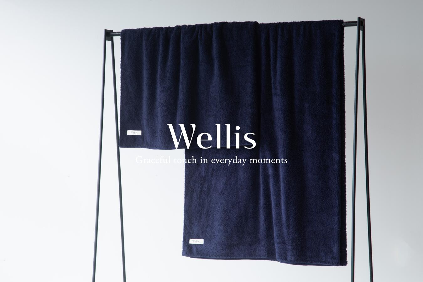 商品説明 セット内容 Wellis プレミアムオーガニック・ブランケット：2枚（幅145cm/長さ90cm） カラー：ネイビー ※ギフトボックスに入れて配送させて頂きます。 ※写真はイメージです。 謝礼品紹介文 Wellisは、朝目覚めてから、眠りにつくまでの何気ないシーンの中で、肌に触れるタオルなどのアイテムを中心に揃えたライフスタイルブランドです。 『優しく美しい肌ざわり』を探求した商品やサービスを通じて、自分の肌と触れるたびに、しあわせな気持ちで満たされる「優美で心地よい日々」をお届けしています。 私たちWellisは、時代と共に変わり続けるくらしと向き合い、日本が誇る希少な技術を用いて、最高品質のものづくりにこだわっています。そして、地場産業とお客様をつなぐ循環型ビジネスモデルを通じて、日本の地場産業の振興に貢献し、希少な職人技術によるものづくりを残していきたいと考えています。 ブランケット2枚セットです。Wellisのブランケットには、オーガニックスーピマコットンを使用しており、特徴として繊維が長く繊細であり、肌ざわりが非常に優れています。イタリア製レピア織機で泉州の熟練タオル職人によって特別な織り方で作ることによって、そのパイルの長さ、ボリュームからは想像が付かない軽くふわりとした質感を実現しました。 一般的なブランケットと比べて、調湿性と通気性によって夏の暑い夜でも快適な眠りを提供する『優しく美しい肌ざわり』のブランケットは、大切な人への贈り物やお祝い返しなどにぜひお選びください。 日本最高峰のものづくりを。Wellisのタオル3つのこだわり 1.極甘撚りの追及による、『優しく美しい肌ざわり』が与える心地よい眠り ブランケットを開発する時、Wellisが追及したのは、「暑い時に感じる清涼感、暑さがこもらない快適な睡眠」「寒い時に感じる温暖感、温かさを留めることによる快適な睡眠」その対照的な使用感を両立させるためには、繊維が長い超長綿であるスーピマ100％使用によって実現した「極甘撚り糸」が必要でした。 極甘撚りにすることによって、繊維の間に空気を多く含むことによって調湿性を高め、季節・気温に応じた性質を持ち、柔らかな肌ざわりも同時に実現することができました。 2.『優しく美しい肌ざわり』を叶える、Wellisのこだわり Wellisのブランケットは、オーガニックの国際認証を取得したコットン糸で織り上げられています。中でも肌に直接触れるパイル部分には、オーガニックスーピマコットンを採用し、その中でも極甘撚りの優しい糸を使用しています。 パイルとグランド（生地）の糸ともに、加工過程の中では天然の糊によるサイジング、バクテリア漂白、OCS認証に適合した染料を使っています。生産者が糸に込めた想いを最終製品に生かすために、Wellisのプレミアムオーガニックシリーズは製造過程にもこだわっています。 3.緻密な織りの設計と希少な職人の技術 極甘撚りであること、糸が細いこと、天然素材での加工は、タオルを織る際に、糸が切れやすくなり、タオルを織ることを困難にしてしまいます。それでも細い極甘撚りの糸で作られた、最高品質のブランケットをお客さまに届けたい。その思いから、泉州タオルの熟練職人と試行錯誤を重ね開発しました。 そして、こだわりぬいた織機・仕掛け・設計、熟練職人の経験によって、なめらかで光沢感ある美しい風合いの商品が生まれました。 Wellis 関連キーワード ウェリス、泉州タオル、お中元、お歳暮、新築祝い、内祝い、出産祝い、引越し祝い、引き出物、国産タオル、メイドインジャパン、日本製、ギフトセット、ギフトボックス、ギフト、プレゼント、贈り物 【熊取町からのお知らせ】 当該返礼品は、区域内で製織・縫製を行っているため、区域内で当該返礼品の半分以上の付加価値が生じています。 ☆ご入金後の謝礼品変更は承っておりません。ご注意ください。配達指定日は承っておりません。ご了承お願い申上げます。ご入金からお届けまでに2～3か月ほどかかる場合があります。ご了承ください。 ・ふるさと納税よくある質問はこちら ・寄付申込みのキャンセル、返礼品の変更・返品はできません。あらかじめご了承ください。「ふるさと納税」寄附金は、下記の事業を推進する財源として活用してまいります。 寄附を希望される皆さまの想いでお選びください。 (1) 使途を指定しない（町長お任せ） (2) 子育て・教育の充実に関する事業 (3) 健康・医療又は福祉の充実に関する事業 (4) 安心・安全なまちづくりの実現に関する事業 (5) 産業振興・地域活性化の促進に関する事業 (6) 自然環境の保全又は脱炭素社会の実現に関する事業 (7) その他（具体的に） ※使い道のご希望がある場合は、用途指定欄の下にご記入ください。