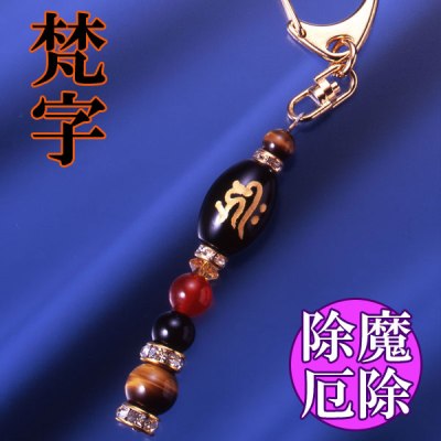 「ピンピン元気カード」付き〇守護梵字 御守護符〇梵字とは仏教、とくに密教と密接な結びつきがあり、古代サンスクリット語の基礎にもなっている文字で、各仏菩薩たちをあらわしています。そして『生まれ年（干支）』によって決まる『守護尊』をあらわしたものを守護梵字といいます。この八種類の梵字にはそれぞれ1文字で御仏の功徳をあらわすとされ、干支の守り本尊とされています。≪黄水晶≫水晶は古代より不思議な霊力がある石と伝えられ、身につけている人を災いから守り数々の奇跡を起こすといわれています。そして風水において黄色は金運色であり、黄色(金色)身につけていると金運・財運が授かるといわれています。≪虎目石≫虎眼石は『虎の目はすべてを見通す』と考えられているため、災厄を避け、成功をもたらす石とされています。金運はもちろん、あらゆる吉運を招くとされ、強力な邪気祓いとしても用いられてきました。また、直感力や決断力を高め、迷いが生じた時も本当に必要なものを見極められる正しい判断ができるよう導いてくれます。≪オニキス≫オニキスには古くから邪念や邪気を祓い、意志や信念を強めて安定させるパワーがあるといわれています。「精神力を強くしたい人」「邪念・邪気を祓いたい人」にぴったりです。≪赤メノウ≫行動力、自己実現など人のやる気をおこさせるパワーを持っているとされています。また肉体と精神を活性化させるといわれ、健康運や長寿祈願にも用いられます。【規格】黄水晶1個（6×3mm/カット）、虎目石1個（10mm珠）、1個（6mm珠）、赤メノウ1個（8mm珠）、オニキス1個（18×12mm 梵字刻印）、1個（8mm珠）、ロンデル2個（8×4mm 真鍮/ラインストーン）、2個（6×3mm 真鍮/ラインストーン）[サイズ]約11cm[重量]約13g[中糸]ステンレスワイヤー[金具]真鍮（カニ爪型キーホルダー52mm）[付属品]専用巾着袋、ピンピン元気カード[個装サイズ]縦13.8×横8.5×高さ1.5（cm）／18.0（g）