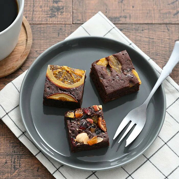 濃厚チョコにナッツとドライフルーツをぎゅっと。ひと口サイズで楽しむ贅沢ブラウニー濃厚でしっとりとしたチョコレート生地に、香ばしいナッツや甘酸っぱいドライフルーツを贅沢にトッピングした「ナッツとドライフルーツの贅沢ブラウニー」。約4cmのキューブに、パイナップルやネーブルなどのフルーツとナッツをぎゅっと詰め込み、ひと口ごとに異なる食感と味わいを楽しめる3種類のセットに仕上げました。封を開けると広がるカカオの香りと、甘すぎない濃厚なチョコの味わい、ナッツのザクザクとした香ばしさ、ドライフルーツの甘酸っぱさが絶妙に調和。 見た目にも華やかで、大人のおやつやちょっと贅沢なティータイムにもおすすめです。■内容量：ネーブル・パイナップル・ドライフルーツ&ナッツ×各1個 ※こちらの商品はのし・包装を承ることができません。■アレルギー：卵・乳・小麦・くるみ■保存方法：常温■賞味期限：お届け時点で40日以上■サイズ：165×40×155mm（パッケージサイズ）■JANコード：4542511345240※こちらの商品は単品商品となります。ラッピング、熨斗等は不可となりますのでご了承ください。 ※当商品は、手作りの工程を含むため、ナッツやドライフルーツの配置や量に個体差が生じる場合がございます。 販売期間：～2027年1月末予定 商品終売や変更につきましては、1か月前にメルマガおよび新着情報にてご案内いたします。 ※やむを得ない事情により、事前のご案内なしで終売・変更となる場合もございます。あらかじめご了承ください。