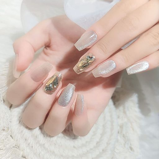 キャットアイ石を贅沢に使用した爽やかなアイスブルーのネイルアート、ストーンをあしらった完成品のネイルチップ