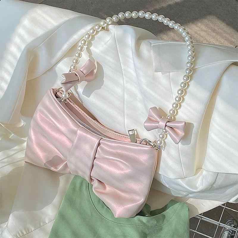 少女用 バッグ 女性用 肩掛け 手提げ 斜め掛け バゲットバッグ 蝶結び アクセサリー ピンク系 アイボリー 珠光 光沢 加工 PU レザー 再生繊維 ポリエステル 裏地 ソフト 素材 柔軟 形状 小型 日常使い 通勤 通学 軽量 コンパクト 都市 シン