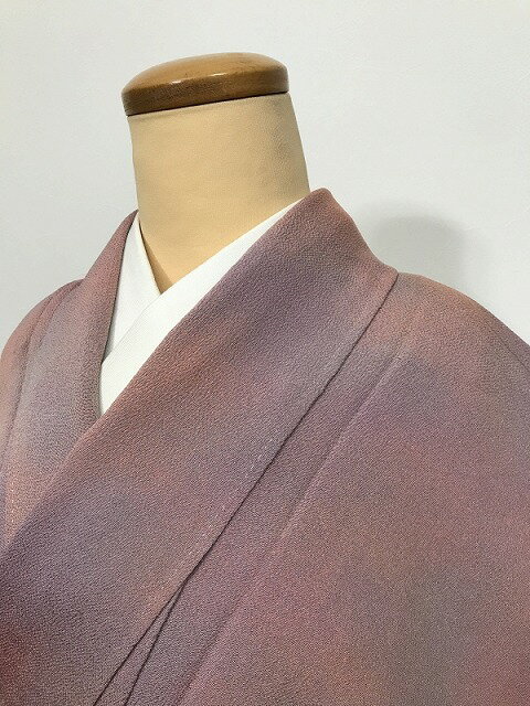 商品説明：シボ感の良い曙色地にグレー ピンクのぼかし染め背には剣片喰芥子縫い一つ紋付 サイズ：裄62、身丈150、袖丈44、前幅22.5、後幅28.5cm 素材：正絹 状態：ランク3 クスミ シミ 黄変有 TPO：水屋着等 仕立て：手縫い 広衿 単衣