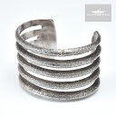 部族NAVAJO（ナバホ） 作者Olin Tsingine （オーリン・セナジーニ） 品名BRACELET（ブレスレット） 素材スターリングシルバー サイズ A.幅　：約39mm B.内周：約131mm C.内幅：約59mm D.開口部：約32mm ●本製品はハンドメイドによる1点ものです。上記写真の商品そのものを発送致しますが、ご使用のブラウザによっては色の見え方が若干異なる場合が御座いますので予めご了承下さい。 ●シルバーに細かな傷・擦れが見られますが制作によるものですので予めご了承下さい。 ●インディアンジュエリーにはハンドメイド特有の歪みやずれがあるため、表示サイズには多少の誤差が生じる場合がございます。 ●本製品はサイズを縮めたり、広げるなどの負荷をかけますと破損する恐れがございます。ご自身でのサイズ調整は行わないで下さい。ご注文の際は商品スペックをご参照の上、サイズがご不明な場合は当店までお問い合わせ下さい。尚、ご自身でサイズ調整をされ破損した場合の返品・返金及び交換は一切お受けできませんので予めご了承下さい。NATIVE AMERICAN HAND MADE JEWELRY NAVAJO Olin Tsingine TUFA CASTED SHANK BRACELET ナバホ族 オーリン・セナジーニ トゥファキャスト シャンク ブレスレット 本製品は、ナバホ族の若手アーティスト「Olin Tsingine （オーリン・セナジーニ）」によって制作されたブレスレットです。 本製品はトゥファストーンと呼ばれる石灰質の石にシルバーを流し込み成型する技術「トゥファキャスト」を用いて制作した2枚の銀板を重ね合わせております。