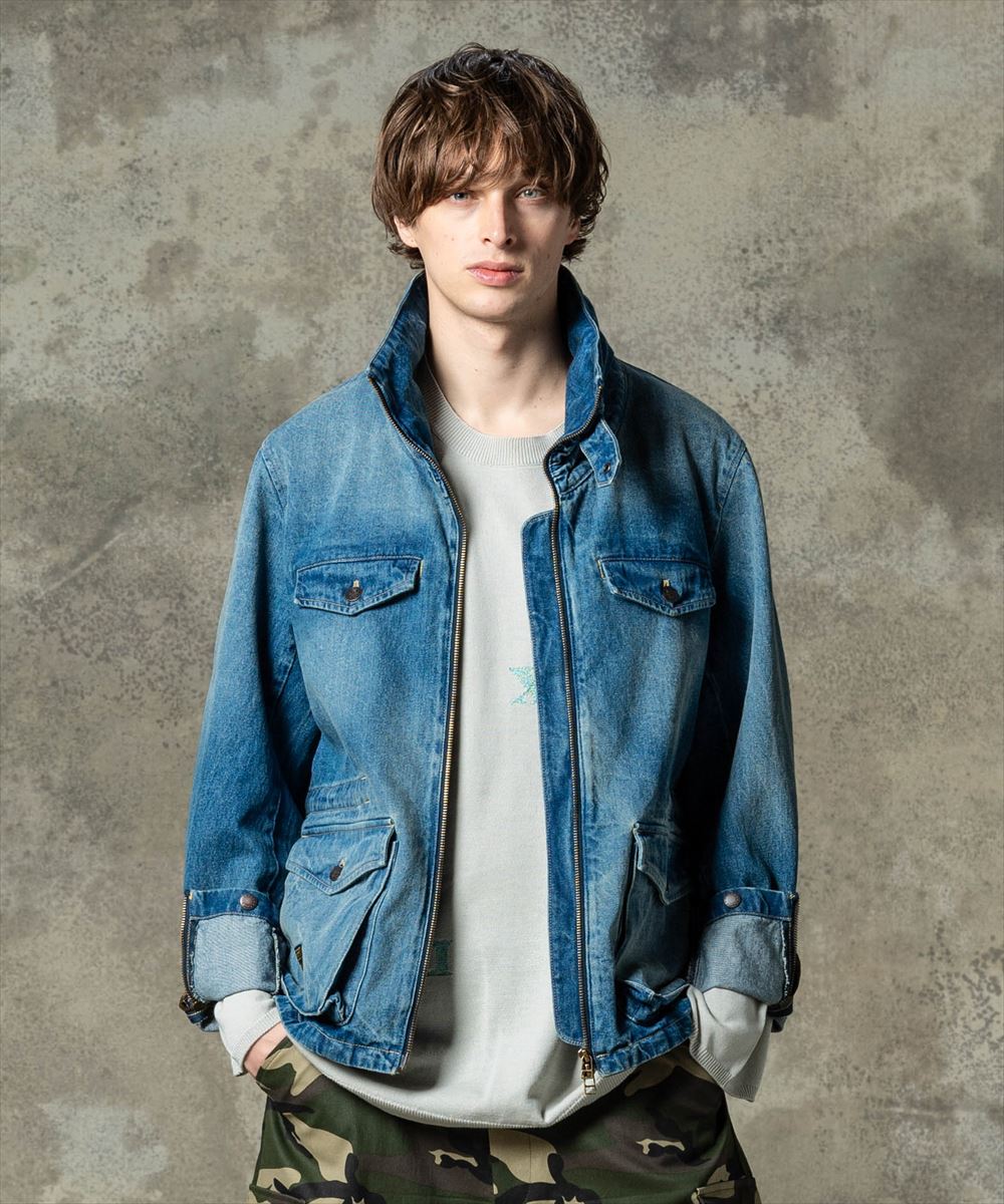 “STUNN”をコレクションテーマに掲げて既存のストリートウェアへ再解釈を施す今季のglamb、その方法論をミリタリーウェアへ落とし込んだSTUNN M-65。ベースとなるボディはM-65を踏襲しながら、ハイネックに変更した首元はギャザーを付けて縫製することでドレープある表情に。さらに背面には“STUNN”コレクションのシリーズディテールであるクロスステッチを加えて仕立て上げました。変化ある造形に合わせ、テキスタイルにはミリタリー生地ではなくストレッチ混デニムを使用。ブランドのデニムクラフトが発揮されたIndigoに加えて、デニム加工のムラに合わせてパラフィンを塗り込んだBlackもラインナップ。こちらは納品時からうっすらと覗く地の色が着込むほどに表出し、独自の経年変化を楽しませてくれます。 【ご注意】予約商品・お取り寄せ商品（納期10日間以上）のキャンセル、変更はお断りしております。＊クレジット払いの場合、実際の決済はお客様へ商品発送後となります。 素材 サイズ・素材画像参照 サイズ サイズ・素材画像参照 モデル着用サイズ モデル着用サイズ画像参照 ※サイズの測り方は、サイズガイドページを参照ください。 カラー カラー表参照 ご注意 【店舗完売やお取り寄せ不可によるキャンセルについて】このWEBショップで販売中の商品は、実店舗や他WEBショップの在庫数が反映されています。反映にはタイムラグがあるので、在庫変動があった場合、タイミングによってはご用意ができない場合がございます。万が一ご用意ができなかった場合は、メールにてご連絡いたしますので、あらかじめご了承ください。※商品写真はできるだけ現物に近い色に見えるよう撮影いたしておりますが、ユーザー様のモニターやPCの環境により、色の見え方に差異が生じる場合もございますのでご了承くださいませ。