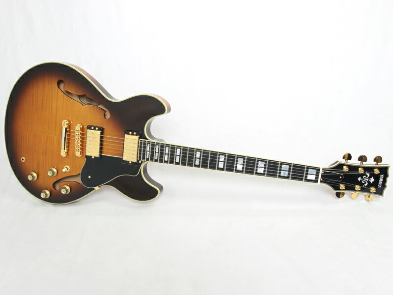 不動の人気を誇るヤマハSAシリーズ。 60年代より脈々と受け継がれるアイデンティティ溢れる本シリーズは幾多のモデルチェンジを重ねて&quot;今&quot;に照準を合わせたいつの時代も最先端をいくセミアコとなっております。 国産メイドの高きクォリティーを存分に感じさせてくれる仕上がり。 スッと馴染むネックフィール、良質な生鳴りは安心の一言。同価格帯でも一線を画すサウンドを持っています。 見るも美しく描いたアーチトップはフレイムメイプルがトップとバックに配され高級感のある仕上がりです。 王道のボディ、ネック構成に指板はエボニーを採用しておりスピード感のあるサウンドを持ちヤマハらしいトーンに一役買っているように思います。歪みのノリも良いのでクランチ〜オーバードライブにおけるロングサスティン、パンチ力はこのモデルならではと言えます。 また、フロントPU、リアPU共にコイルタップが可能なオリジナルピックアップを搭載。それぞれのトーンつまみを引き上げるだけでハムバッキング&rarr;シングルコイルに切り替えることが可能で全8通りの多彩な音色で様々な音楽ジャンルに対応します。 ヤマハ独自の処理である&quot;IRA (イニシャル・レスポンス・アクセラレーション)&quot;による弾きこまれることによる各部の馴染みがもたらすトーンの安定性、一体となって響くようなサウンドを実現しており新品とは思えぬ豊かな鳴りが特徴です。 なかなか生産の安定しない国産ヤマハのセミアコ。 高級感あふれるルックスと素晴らしいトーンを持つ最先端のセミアコトーンを是非お試しください。 ケースは別売です。 画像は以前の入荷時に撮影したものです。お届けの商品とは木目や色合いが異なる場合がございます。 他のサイトでも販売しています。買い物かごに入れても売り切れの場合がございますのであらかじめご了承下さいませ。 Spec. ●ボディ : アーチド・メイプル＋シカモア（トップ＆バック）、バーチ＋シカモア（サイド）、メイプル＋スプルース（センターブロック） ●ボディ/ネック構造 : セットインネック ●ネック : マホガニー ●指板 : エボニー ●指板アール : 350R ●フレット数 : 22 ●ブリッジ : TSG-1G ●ペグ : ゴールド ●スケール : 628mm ●ピックアップ : &rdquo;SAH-SAIIG（アルニコV）&rdquo; x 2 ●コントロール : フロント及びリア・ボリューム、フロント及びリア・トーン（バイサウンド・スイッチ） ●ピックアップスイッチ : 3P セレクタースイッチ