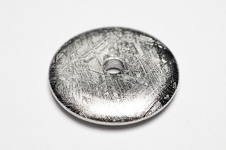 2.7×2.7×0.4cm 穴サイズ:約4mm 綺麗な格子模様が出ているギベオンのドーナツです。かなり大き目の穴が空いておりますので、革ヒモなどに通してペンダントトップとしてお使いいただけます。 表面は錆びにくいようにロジウムでコーティング...