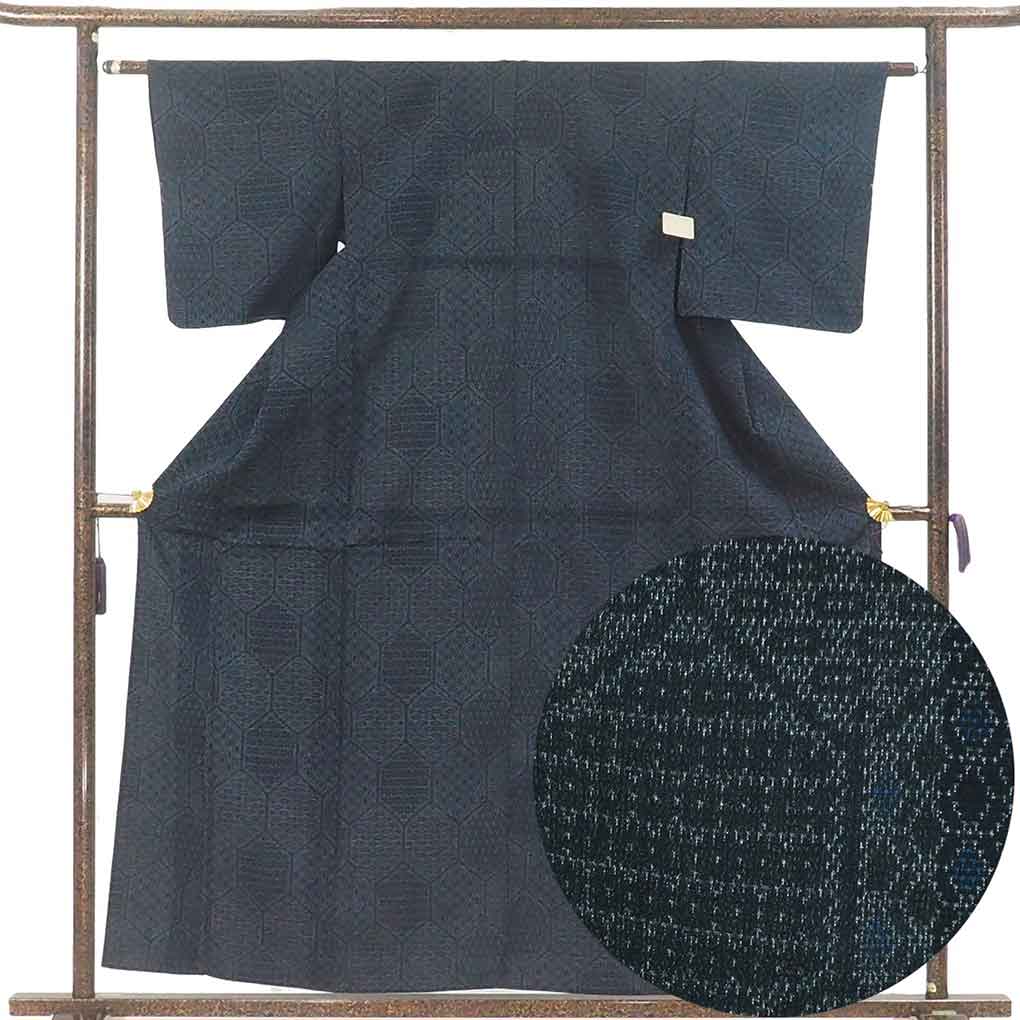 ギフト対応についてはこちらをご覧ください 正絹の単衣紬着物です。紺地の亀甲柄で塩沢のようなシャリ感のある生地ですので涼しくお召しいただけます。身長155cm-165cm程度、やや細身から標準体型の方にお勧めサイズです。広衿仕立て。裄の縫い代は5cm程度ありそうです。しつけ糸つきの未着用品で表地は特に気になるシミ等は見当たりません。衿裏は一部ホック跡がございます（写真6）。【サイズ】身丈160cm 