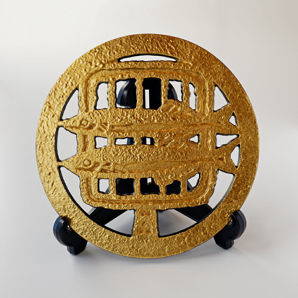 ◆ 金箔 飾り瓶敷 愛着の湧く5種類の柄に金箔を施した鋳物製の瓶敷です。観賞用としてお楽しみください。スタンド付き。 サイズ(cm) Φ18.4×1.9 素材 鋳物(鉄製)、金箔 付属品 スタンド　(閉じた状態のサイズ:11.0×14.5×2.0) 使用上の注意 擦ったり外傷を与えると箔が剥がれる恐れがございます。 十分にお気をつけください。 ※ご了承ください※ ・1つ1つ手作りのため、形や大きさ、イメージ,顔の表情が異なる場合がございます。 ・当店では実店舗でも並行して販売をしておりますので、注文可能な商品でもタイミングによっては売り切れとなる場合がございます。 ・在庫状況によっては生産後の発送となり、発送までにお時間を頂く場合がございます。