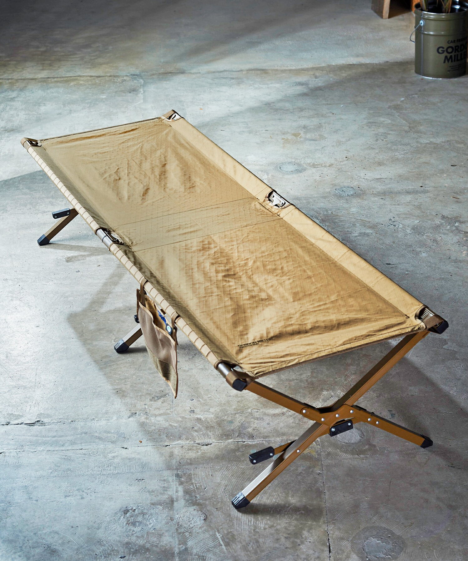 GORDON MILLER X-PAC FOLDING COT ガレージライフスタイルブランドより19年秋冬シーズンにリリースした、 MOLEシスムを採用し自由に組み合わせ可能なカーインテリア & バッグ、通称「TACTICAL PAC / タクティカルパック」より ガレージファニチャーが仲間入り。コット、ベンチ、チェアとテーブルを含めた4型からなる新コレクション。 素材はバッグやシートカバー同様の米・Dimension-Polyant社製の表生地 ＋ X-PLAY(ファイバー) ＋ 裏生地という3種類の 生地を特殊な方法で張り合わせた3層構造となる、強度・軽さ・防水性を兼ね備えた、主にヨットのセイルクロスとして使われる特殊マテリアル 「X-PAC / エックスパック」素材をメインに使用し、MOLEシステムによるバッグなどとの連動制ももちろん踏襲。 ウッド部分は、アウトドアファニチャーには通常使われない楡(ニレ)材を取り入れ、 その美しい見た目と質感、さらには経年変化の楽しさも味わえるコレクションとなっている。（コットには楡材を使用しておりません） 米・Dimension Polyant社製の特殊マテリアル「X-PAC / エックスパック」素材を贅沢に使用したコット。 一般的なコットと違い、強度・軽さ・防水性を兼ね備えた、主にヨットのセイルクロスとして使われるX?PACなら生地の伸びがほぼ無く、長く愛用することが可能。 組み立ては、最後にステップを踏むことで張地にワンタッチでテンションをかける非常に楽な構造。 側面にモールシステムがあり、付属の吊りポケットやTACTICAL PACのティッシュケースやドリンクケースなどを取り付け可能。 コンパクトに折りたたむ事ができ、便利な収納バッグ付き。 【お手入れ方法】 ・使用後は汚れや水気をよく拭き取って乾燥させていください。 ・汚れたまま、または濡れたまま長時間放置しますと色移りやカビが発生する恐れがあり、劣化しやすくなるのでご注意ください。 ■重量：6.2kg ■素材 ・張り地（表）：ナイロン57％、ポリエステル43％ ・フレーム：アルミニウム合金 ■原産国：中国 ■コード：01603554 ※掲載商品は複数店舗で在庫を共有している商品も御座います。 在庫数の更新は随時行っておりますが、タイミングにより在庫にずれが生じることがございます。 そのためサイトよりご注文を頂いた時点で稀に他店舗にて完売しており、欠品してしまう場合が御座います。 在庫管理は出来る限り迅速な更新を心がけておりますが、万が一欠品の際はご了承下さい。 【ご購入の前にご確認ください】 ※お客様のモニターの設定や閲覧環境(OSやブラウザのバージョン)によって、 画面上と商品実物との色味が若干異なる場合があります。あらかじめご了承ください。 【配送につきまして】 平日11時までのご注文分は即日出荷致します。土日祝のご注文は翌営業日の対応とさせていただきます。 大雨、大雪などの天候不良、地震などの災害、お正月、お盆などの交通渋滞などの不可抗力の事態により、 商品をご指定の日時にお届け出来ない、遅れてしまう場合がございます。予めご了承ください。 詳細に関しましては、下記の各運送会社様へお問い合わせください。 ■佐川急便 【お問い合わせ】 その他のお問い合わせにつきましてはお問合せフォームよりご連絡ください。