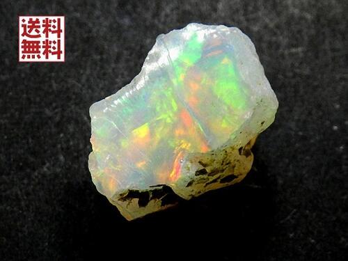 表裏面に綺麗なオパール層が見られます。 プレシャスオパール（遊色オパール） 出品のオパールはエチオピア ウェロー州産です。 流紋岩からなる溶岩台地付近に分布する凝灰岩の中から採掘されたオパールです。 オパールの中でも、遊色を示すものはプレシャス・オパールと呼ばれ重宝されます。 このチラチラと虹色に輝く光の現象（遊色）は、石に含まれる水分が光を分散することで発生します。 出品の原石ですがこのまま乾燥した状態で品質を保っております。 オパールは水中保存が望ましいといいますが、 エチオピアオパールに関しては水に入れてしまうと遊色効果は強くなりますが透明感のある部分は真っ白に濁ります。 このまま保管するのが望ましいと言われています。 重さ 14.30ct（カラット） サイズ　18×13×12ミリ 産地 エチオピア産 角度によって色の雰囲気が変わります。あらかじめご理解下さいますようお願い致します。　