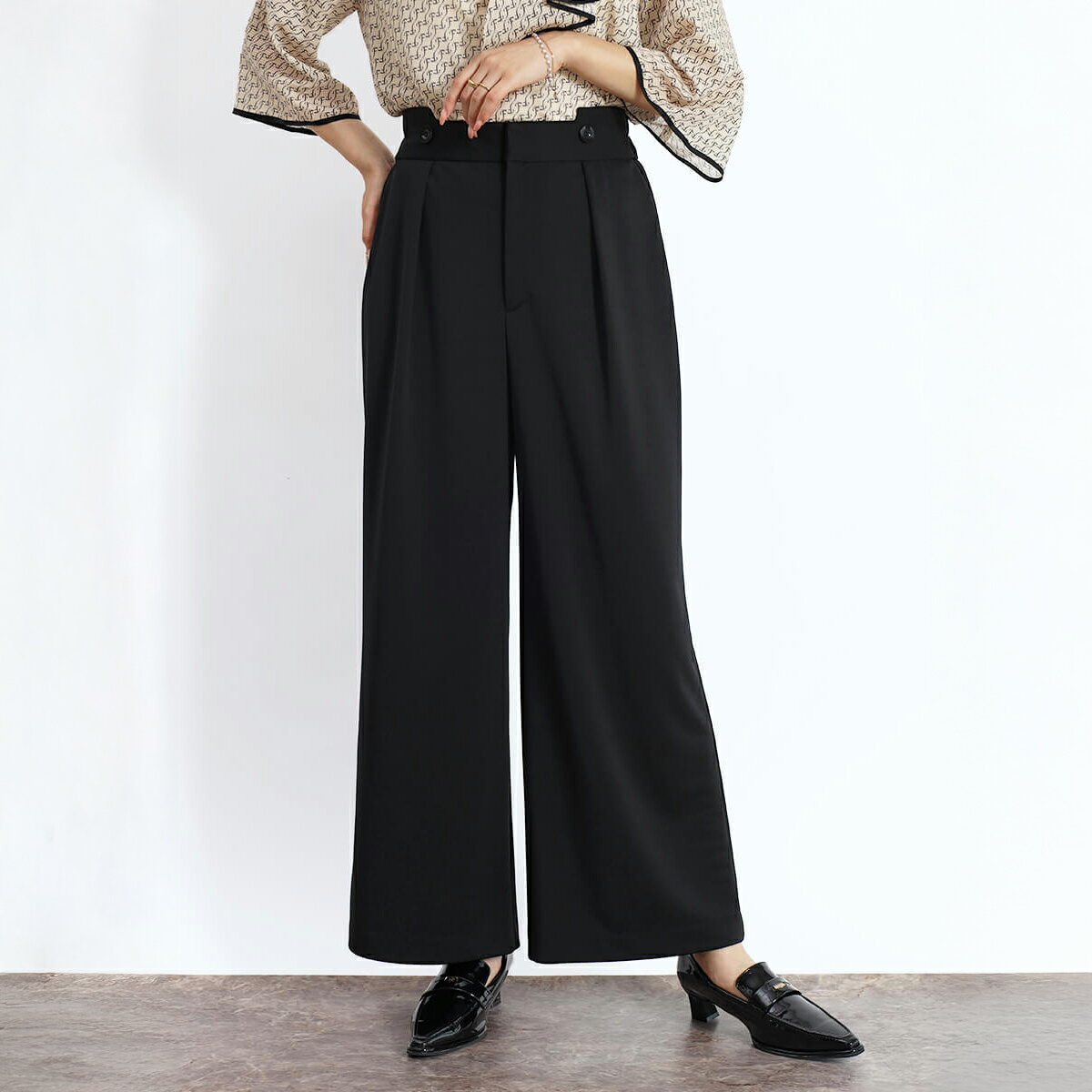 遊び心あふれるウエストデザインが印象的なワイドパンツ。 フロントのボタン使いとカッティングがアクセントとなり、シンプルながらもさりげなく個性を演出します。 ストレッチ性のある程よい厚みの生地は、体のラインを拾わずエレガントなシルエットを実現。 ご家庭での洗濯が可能で、お手入れのしやすさも嬉しいポイントです。 ベーシックなデザインでありながら汎用性が高く、オケージョンから普段使いまで幅広く活躍。 オンオフ問わず様々なシーンでスタイリッシュに着こなせるおすすめの1本です。 &nbsp; モデル：166cm ※撮影画像は、光の当たり具合やお使いのモニター設定、お部屋の照明等により実際の商品と色味が異なる場合がございます。一番実物に近いお色味は生地画像でございます。 &nbsp; 【商品詳細】 ・サイズ　パンツ丈（前／後）98cm／100cm　ウエスト幅（前／後）4.5cm／6cm　ウエスト66cm～74cm　ヒップ100cm　股上（前／後）32.5cm／35cm　股下69cm　わたり幅34cm ・素材　ポリエステル：100％ ・透け感　なし ・伸縮性　若干あり ・原産国　日本 ・家庭洗濯　手洗い可 ・ポケット　あり ・裏地　なし ・ウエスト　後ろ部分ゴム仕様