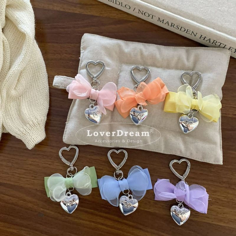 可愛らしいリボン付きのバッグチャームキーホルダーです。韓国ファッションを取り入れたデザインで、あなたのバッグを一層華やかに演出します。様々なカラーからお選びいただけますので、お好みに合わせてコーディネートを楽しんでください。