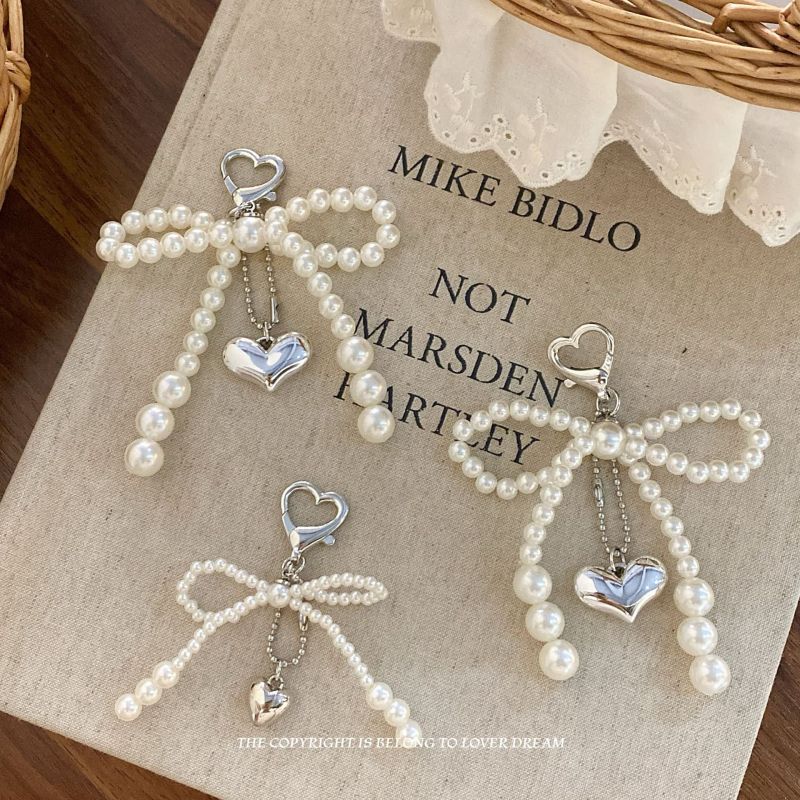 このバッグチャームは、韓国ファッションのトレンドを取り入れた可愛らしいデザインです。リボンとハートのモチーフが特徴で、どんなバッグにもぴったりのアクセサリーです。サイズはS、M、Lから選べ、あなたのスタイルに合わせてお楽しみいただけます。