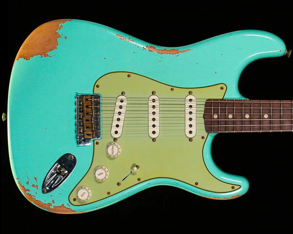 Description 1987年に設立され、最上級モデルを制作するために生まれたフェンダー・カスタム・ショップ（Fender Custom Shop）。マスタービルダーと呼ばれる巨匠達が製作を担当するマスタービルダー・シリーズやその他の多くのシリーズで厳選された木材選び、ピックアップのコイル巻きなど高い製作技術で作り上げられております。フェンダー社の長年の歴史と伝統が注ぎ込まれた世界中のミュージシャンから愛され続けるセクションです。 ディーラー・オーダーによるカタログ外モデル「1961 STRATOCASTER HEAVY RELIC」のご紹介です。1960年ストラトキャスターをベースに製作され、ボディには低～高音域までクセの無いサウンドをアウトプットする2ピース・アルダー、25.5インチ・スケールのネックには硬めでクリアかつ歯切れの良いメイプル材、21フレット仕様の指板には倍音豊かで優れたサスティーンを生むAAAグレードのスラブ貼りフラット・ラミネイト・ローズウッドを採用。フラット・ラミネイト（スラブ貼り）の指板からは、1959年～1962年の特徴であるローズウッド指板とネックとの接着面が平面である『スラブ・ボード』によりローズウッドの使用量が大きくなりますので、マイルドかつ太めのサウンドを生み出します。ネック・シェイプはローポジションからハイポジションまで薄く仕上げられている「60 Style Oval C」、あらゆるプレイスタイルに最適な9.5Rの指板、フレットにはミディアム・ジャンボよりも少し幅が狭く高さのある「Narrow Tall」を採用するなどピッチの安定したスムーズなフィンガリングを可能にいたします。 ピックアップ・システムにはハンドワウンド（手巻き）によって丁寧に製作された「1960 Strat」を搭載し、綿密な測定に基づき、設計されたピックアップで、繊細でクリアな表現力を持ち、タイトで芯の強さをも兼ね備えた張りのあるサウンドです。エイジング処理は塗装が剥げて来た絶妙な風合いを演出する圧巻のヘヴィ・レリック加工を施し、さすがはカスタムショップと言うに相応しい出来映えです。現代的なスペックと極上のヴィンテージ・サウンドがお楽しみ頂けるモデルに仕上がっております。 Specification Body: 2-Piece Alder Body Finish: Heavy Relic Nitro Control Knobs: Relic White Fingerboard: AAA Rosewood (Flat Lam) Hardware Finish: Nickel Relic Neck Finish: Heavy Relic Lacquer Pickguard: 60 Strat Nitro Position Inlays: Micarta White Neck Material: Maple Plain Grain Neck Shape: '60 Style Oval "C" (.790"-.930") Scale Length: 25.5" Fingerboard Radius: 9.50" Number of Frets: 21 Fret Size: Narrow Tall 6105 String Nut: Bone Nut Width: 1.650" Truss Rod: Vintage Style Bridge Pickup: Custom Shop 1960 Strat Middle Pickup: Custom Shop 1960 Strat Neck Pickup: Custom Shop 1960 Strat Controls: 1 Volume, 2 Tone Pickup Switching: 5-Way Lever Pickup Configuration: SSS Bridge: Custom Shop Synchronized Tremolo Tuning Machines: Vintage Style Case/Gig Bag: Fender Custom Shop Hardshell Case