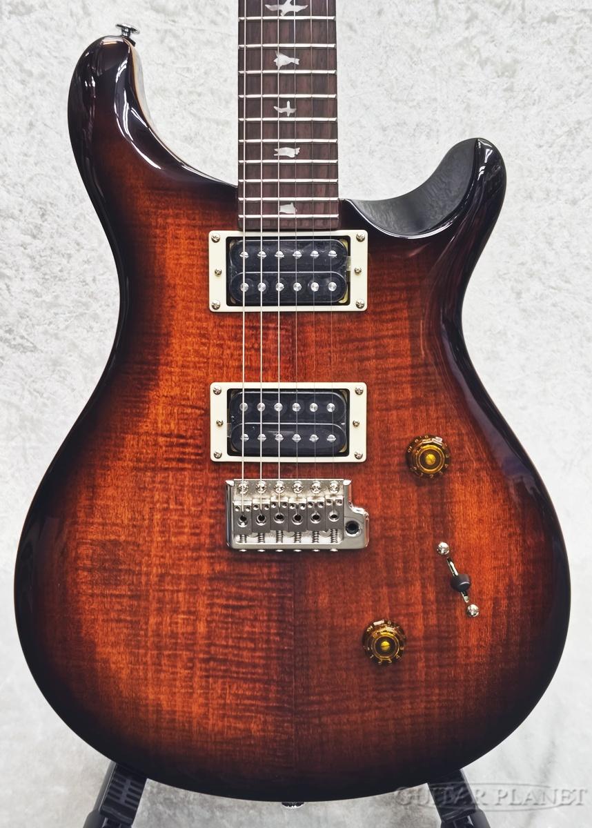 SE Custom 24は、オリジナルのPRSデザイン・プラットフォームを、高品質でお求めやすい価格帯のSEシリーズに導入した1本。 ツアー・アーティストやライブの多いミュージシャンなどから愛用されているSE Custom 24は、マホガニー・バック＋メイプル・トップのボディ、Wide Thinカーブのメイプル・ネックにローズウッド指板＋バード・インレイを合わせ、PRSデザインのトレモロ・ブリッジを装備。 85/15 “S”ピックアップに1ボリューム、プッシュ/プル・タイプのトーン・コントロール、3ウェイ・ブレード・ピックアップ・セレクターによる多彩なサウンド。 クラシカルな中にモダンさを兼ね備え、高い耐久性、病みつきになるほどのプレイアビリティ、そして多彩なトーンの「使える」1本です。 SPEC Top Wood: Maple with Maple Veneer Back Wood: Mahogany Number of Frets: 24 Scale Length: 25 Neck Wood: Maple Fretboard Wood: Rosewood Neck Shape: Wide Thin Fretboard Inlays: Birds Bridge: PRS Patented Tremolo， Molded Tuners: PRS SE Tuners Hardware Type: Nickel Treble Pickup: 85/15 S Bass Pickup: 85/15 S Pickup Switching: Volume and Push-Pull Tone Control with 3-Way Blade Switch /_/_/_/♪出荷前調整のご要望承ります♪_/_/_/_/ ギタープラネットではご注文頂いた商品は 新品中古問わず検品・調整してから出荷致します。 弦高などの細かなセッティング等、お好みに 合わせての調整も可能ですので、お気兼ねなく お申し付けくださいませ。 /_/_/_/_/_/_/_/_/_/_/_/_/_/_/_/_/_/_/_/_/_/_ ※当商品は通信販売に限りご用意が可能でございます。実店舗での実機確認・試奏はお受け出来ませんので予めご了承ください。 ※掲載画像はサンプルになります。実際にお届けする商品とは色味や木目が異なる場合がございますのでご了承ください。 お問い合わせ:03-3259-0031　