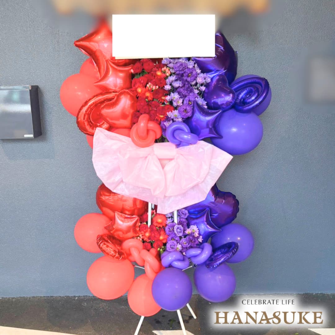 お届け商品 【ショートリボン】【左・右】ハーフ＆ハーフ　バルーンスタンド花2段 お届け日 仕入の関係上、お届けに2〜5日程お日にちを頂く場合がございます。 使用花材 季節の花をメインにおまかせで制作いたします。 サイズ 幅約100cm　x　高さ約180cm　あくまでも目安です。制作内容により異なります。 お届け内容 オアシス入り専用バケツにスタンド台、リボン付き。(リボンの色にご指定がある場合は備考欄へご入力ください。色によってはご対応できない場合もございます。) バケツ部とスタンド台は後日花屋が回収に伺います。 配達エリア 特別対応エリアをご確認ください。但し、注文内容や配達状況によってはお届けが出来ない場合もございます。予めご了承くださいませ。 送料 花助は全国の都市部にある花屋を厳選したフラワーネットワークになります。 都市部であれば送料無料でお届け可能です。 ただ、都市部から離れた郊外へお届けの際は【配送料1,650円（税込）】がかかる場合があります。 ご注文後、配送料については電話もしくはメールにてその旨ご連絡させていただきますのでご安心ください。 無料サービス スタンド花の設置・回収 / 名札 / 配達完了報告 / 画像報告(※画像報告は希望者のみ、配達後5日程度) / 見積書・請求書・領収書 注意 商品ページに掲載されている画像は過去にお届けした一例であり、商品のサンプルではありません。季節・地域によって仕上がりは異なります。予めご了承ください。全国の花贈りに精通したフラワーコンシェルジュが、お客様一人ひとりのご用途に合った、 満足度の高い花屋をその都度厳選し、最高のフラワーギフトを提供します。